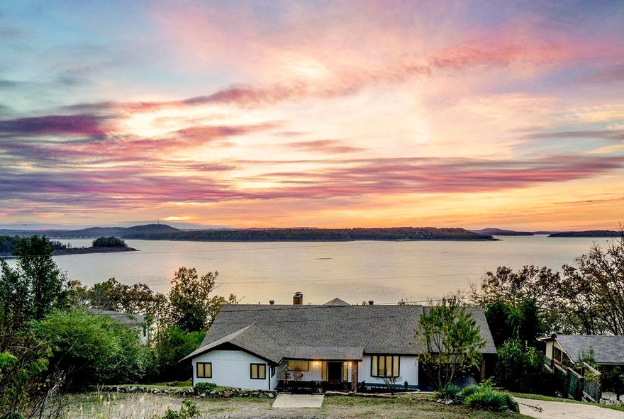 Rare opportunity to own a lakeside paradise! Extensively remodeled, 5 bedroom, 4 bath home offers expansive views of Bull Shoals Lake, plus new shingles 2025, more off-street parking, and outdoor lounge area. Upstairs: open concept, vaulted ceilings, hardwood floors, dining area, 4 bedrooms, breakfast area, two laundry areas and sunroom. Primary bedroom with ensuite bath, walk in closet & private balcony. Downstairs: family room with fireplace, spacious bedroom with ensuite bath and lower deck access, a game room and concrete workshop/safe room. Listen to the waves lap against the shore as you relax on the decks while watching the gorgeous sunsets and panoramic lake view. Successful vacation rental could be sold furnished. Available boat slip nearby, but not included in the price of home.