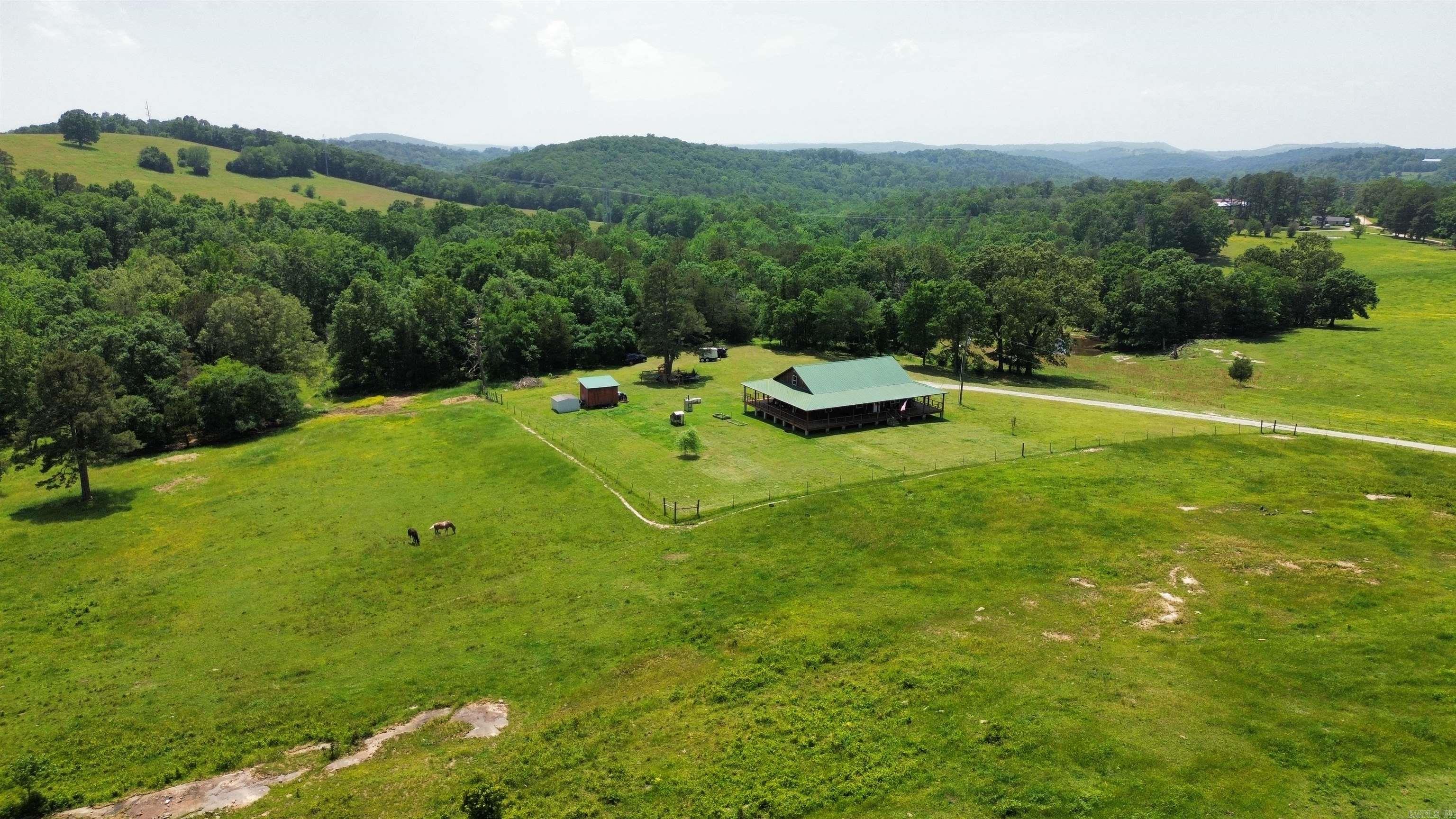 This 4-bedroom, 2-bathroom home sits on 33 acres at 482 Ash Trail in Melbourne, Arkansas. The land is all fenced, with a pond, mostly pastureland, mountain views and plenty of room for animals. This 2,107 square foot house is move-in ready with a wrap-around porch, central heat and air, and offers backup heat from either propane or an outdoor wood furnace. The main level has 3 large bedrooms, a bathroom, laundry room, kitchen, and living room. Upstairs is a loft with a 4th bedroom, another bathroom, and a family room. The property has everything you need for a small farm. There’s also an option to include a stock trailer, chicken coop, tractor, above-ground pool, and even the animals—2 horses and several chickens. It's located in a quiet area but still close to town for schools, stores, and other needs. This is a great setup for someone wanting land, animals, and a home - all ready to go. Priced to sell at $489,900.