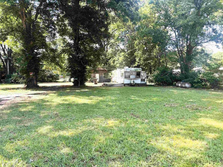 New vacant lot listing on West Poplar!!  This property could make a nice building spot with 2 pretty trees on the lot.  The storage building will remain. The mobile home on the property is in poor condition and is not habitable.