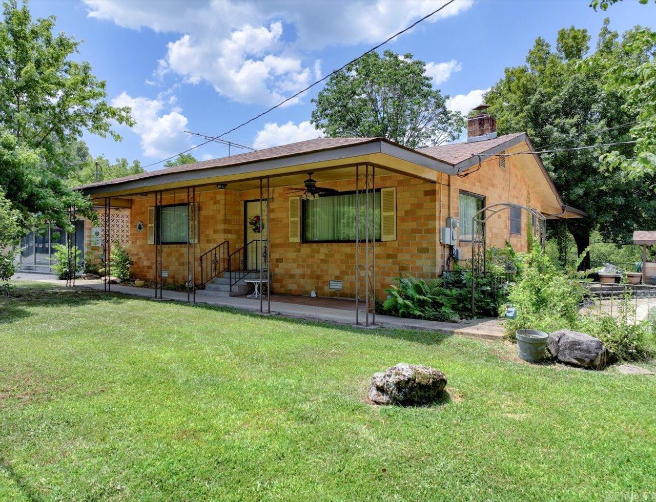 Fantastic opportunity for someone looking to run a business near home. This property package has it all with a 3 bed 1.5 bath brick home, 2 car garage with apartment above, storage building, pool, 3 car garage/barn/workshop, AND a storefront complete with half bath & kitchen! This is a great location with approximately 1.2 acres right on Highway 290 and a little circle drive. You can see Lake Hamilton from the front yard and there is a small creek that borders the back of the property. With a little updating, this property holds endless possibilities!