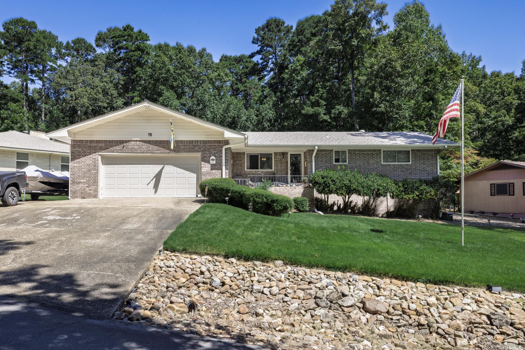 Welcome to this charming 2 bed/2 bath brick home, ideally situated on the west side of HOT SPRINGS VILLAGE. As you step inside, you will be greeted by a warm and inviting living space featuring a cozy brick fireplace with gas starter and a built-in bookcase perfect for quiet evenings. The kitchen is boasting with a functional island and stainless appliances, including a gas stove. (all appliances convey including washer and dryer) The adjacent Arkansas room is 250 sq ft with heat and air, offering a versatile space that can be enjoyed year round. The room opens up to a fenced backyard with stone patio. One of the best features of the property is the backard backs up to common property. Master bath has new shower enclosure and hall bath has newer bathtub and shower door. Whole house generator and shed conveys.