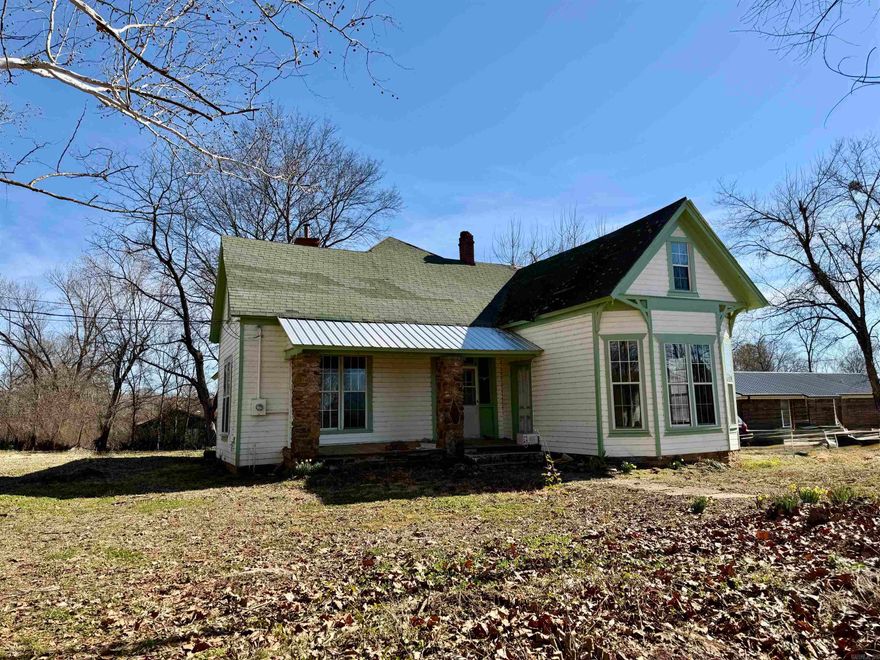 Victorian fixer-upper opportunity on a spacious corner lot in Lamar, full of character and original charm. From the hardwood flooring to the trim, moldings, and doors, many historic features remain intact and ready to be restored to their former beauty. The upper level offers three bedrooms and a bathroom, while the main floor includes a formal dining room, laundry area, and two additional bedrooms—one of which could easily serve as a den or office.  Rich woodwork throughout, fresh exterior paint, and included shingles add value to this restoration project. Recent improvements include newly roughed-in plumbing and electrical systems, giving you a strong head start toward completion. A rare chance to transform a classic Victorian into something truly special.