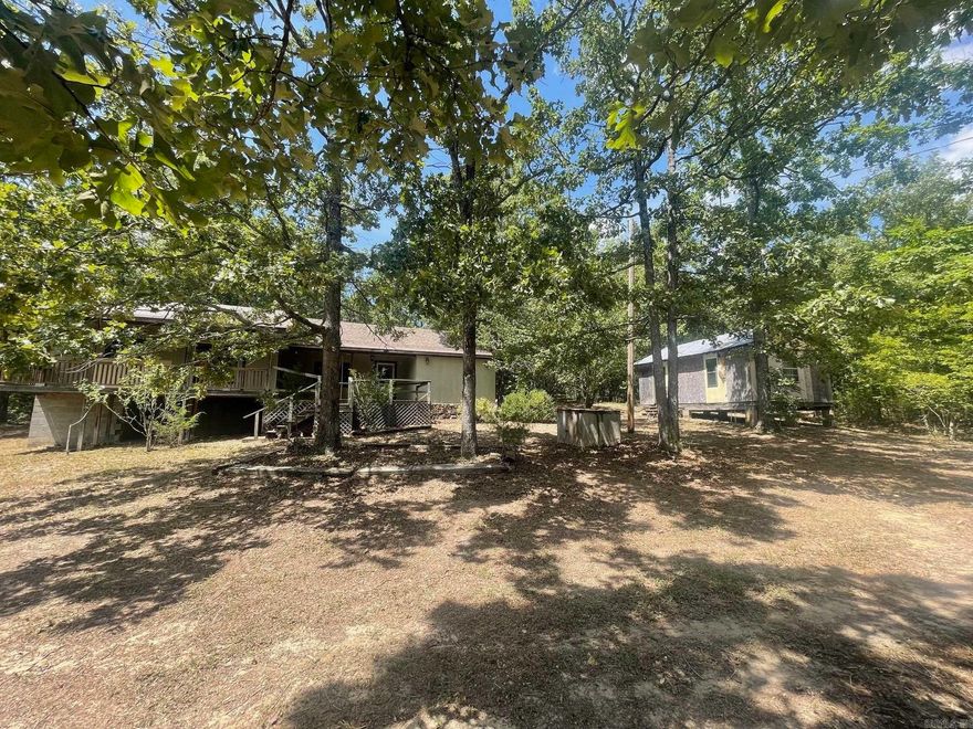 Looking for seclusion with a little bit of land...this is it. The original log cabin (1985) is still there, but has been added onto (1998) and is now over 1,600 square feet. Covered deck across front of home. Of the 3.56 acres, 2 acres can be used as a fully fenced (barbed wire) pasture. Small livestock shed along left of driveway can be used for chickens, pigs, cows, horses, goats, etc. Wet weather stream on the property behind the home. Large stone gas fireplace in living room. Lots of cabinet storage in kitchen. Unfinished room off laundry room can be another bathroom (plumbing already ran), craft room, storage room, nice big closet, etc. Small basement area with sump pump and already plumbed with propane. Cooled with 2 window units. Heated with propane fireplace, 2 wall furnaces, and 2 baseboard heaters. Off the dining area, you will find a staircase to a large loft area over the kitchen. Outside storage building has lots of potential uses. Circle driveway. Less than a 1/4 mile past the cabin is the original dirt road that goes under the lake to Higden. Has access for swimming, kayaking, putting in small fishing boat. No boat launch. Hill Creek is closest marina.