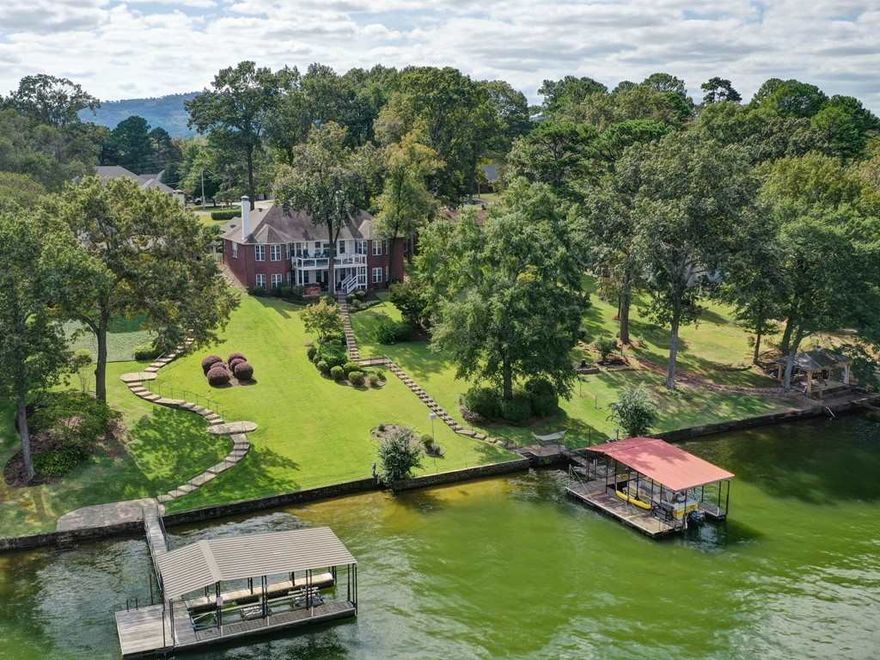 MAGNIFICENT OPPORTUNITY to own this remodeled/updated 6 bedroom, 4.5 bath lake home - great location by land or lake! Walk in level is a master suite + 2 other bedrooms, 14 ft ceiling living rm w/fp & walls of windows overlooking lake, dining area w/fp, granite kitchen 2/brfk bar, SS appliances. Downstairs is fabulous with a bunk room (sleeps 9), another master + 6th bdrm & 2 bathooms. Lower living area w/fp. Upper & lower decks, covered boat dock, hot tub. HIGHLY SUCCESSFUL VRBO OR CAN BE YOUR DREAM HOME!
