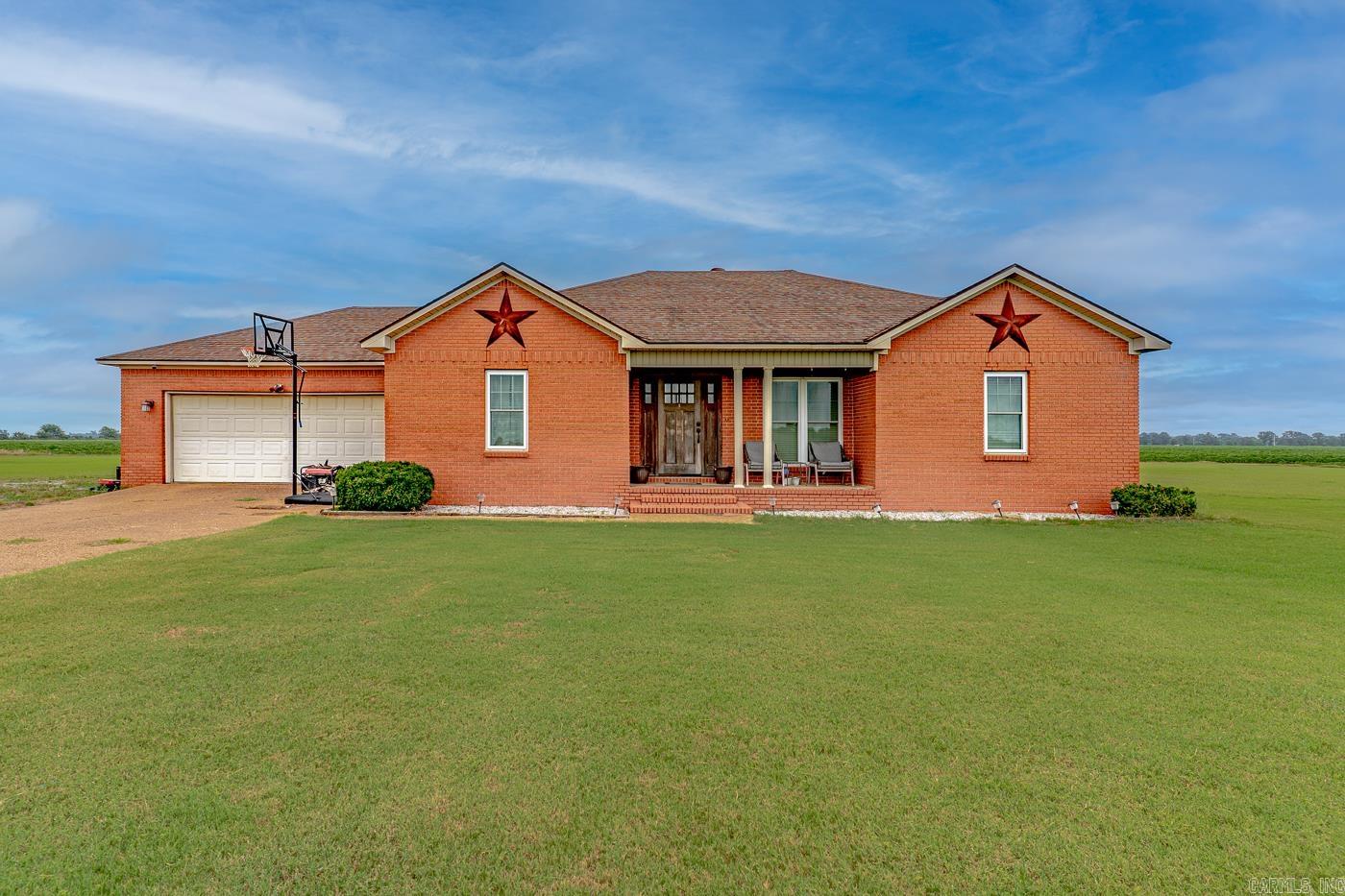 Welcome to Market: 4430 N CR 175 of Manila, to Mississippi County, of the Manila Public School District. Peace. Solitude. A world unto itself with a charming open property, a classic, red brick exterior, and a cozy front porch. Enter into a sizable great room with a coffered ceiling and fireplace and a dining room large enough for family and friends. Discover a perfect galley kitchen with twin counters close enough to be convenient while also being able to cook with a partner. And don’t miss those countertops or the classic, single bowl farmhouse sink. Chef’s kiss. The primary bedroom has an en suite bathroom with jetted tub and walk in shower. While the other two bedrooms contain large, twin door closets. Don’t miss the second bathroom. Outside find a blank canvas: +/- 1.37 acres and fresh as the driven snow with lots of space. Nestled just outside the small town of Manila, AR, you are 4.5 miles from the school, located between Jonesboro and the steel mills, and only about an hour drive to Memphis, TN, if you’re looking for a bigger city for shopping or seeing the sights. You’ll find plenty to love and enjoy in this perfect, secluded hideaway. Call to schedule your viewing today!