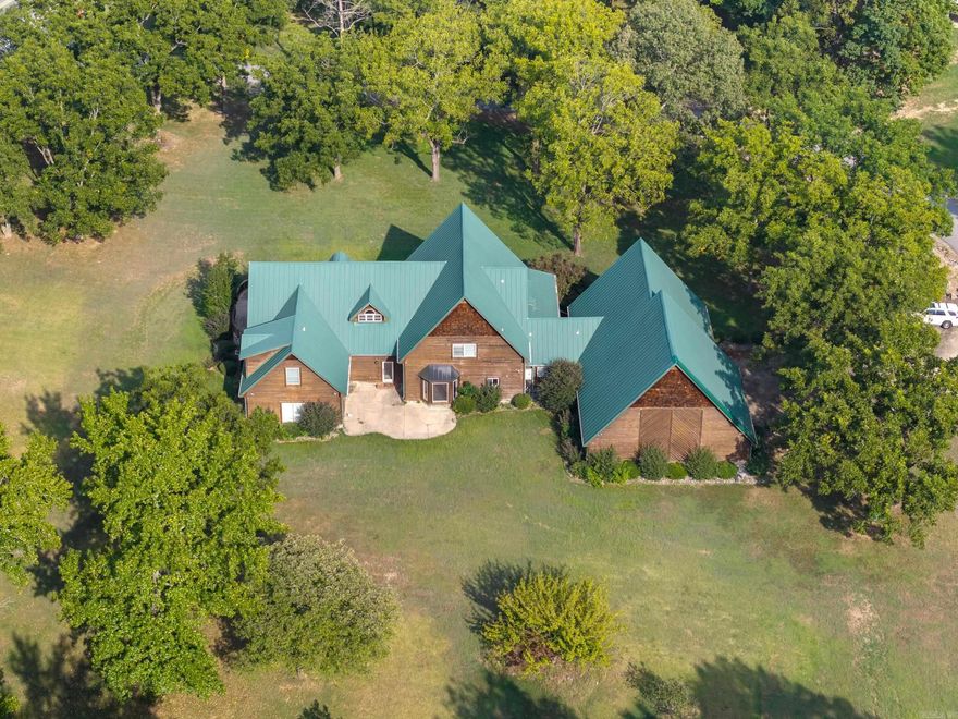 Luxury Living on 3 Ac with a shop! Discover this impressive lodge style 5K+sf estate offering the perfect blend of elegance, comfort & functionality. Situated on 3.09 ac, this property offers 5BR, 4.5BA & multiple living areas. Has two Primary bedrooms (one upstairs, one downstairs) & two optional living areas. The heart of the home boasts a spacious kitchen opening to 2 living rooms & 2 dining areas with tons of natural light from the East facing windows. You will love the cat walk/balcony overlooking the downstairs. In addition, it offers large bathrooms, walk-in closets, a bonus room & incredibly peaceful views of a beautifully rolling property. A rare highlight of this home is the safe room as well as basketball court inside the enormous garage providing endless recreation & fitness opportunities right at home! For hobbyists, entrepreneurs or those needing extra storage the 32x50 shop is incredible and a must see! There is over 1000sf of porch/patio space. This 3 acre property is beautiful, manicured, and has room to garden, play, or simply relax.  This one-of-a-kind property provides upscale living with unique decor perfect for a lifestyle that values both! Agents see remarks