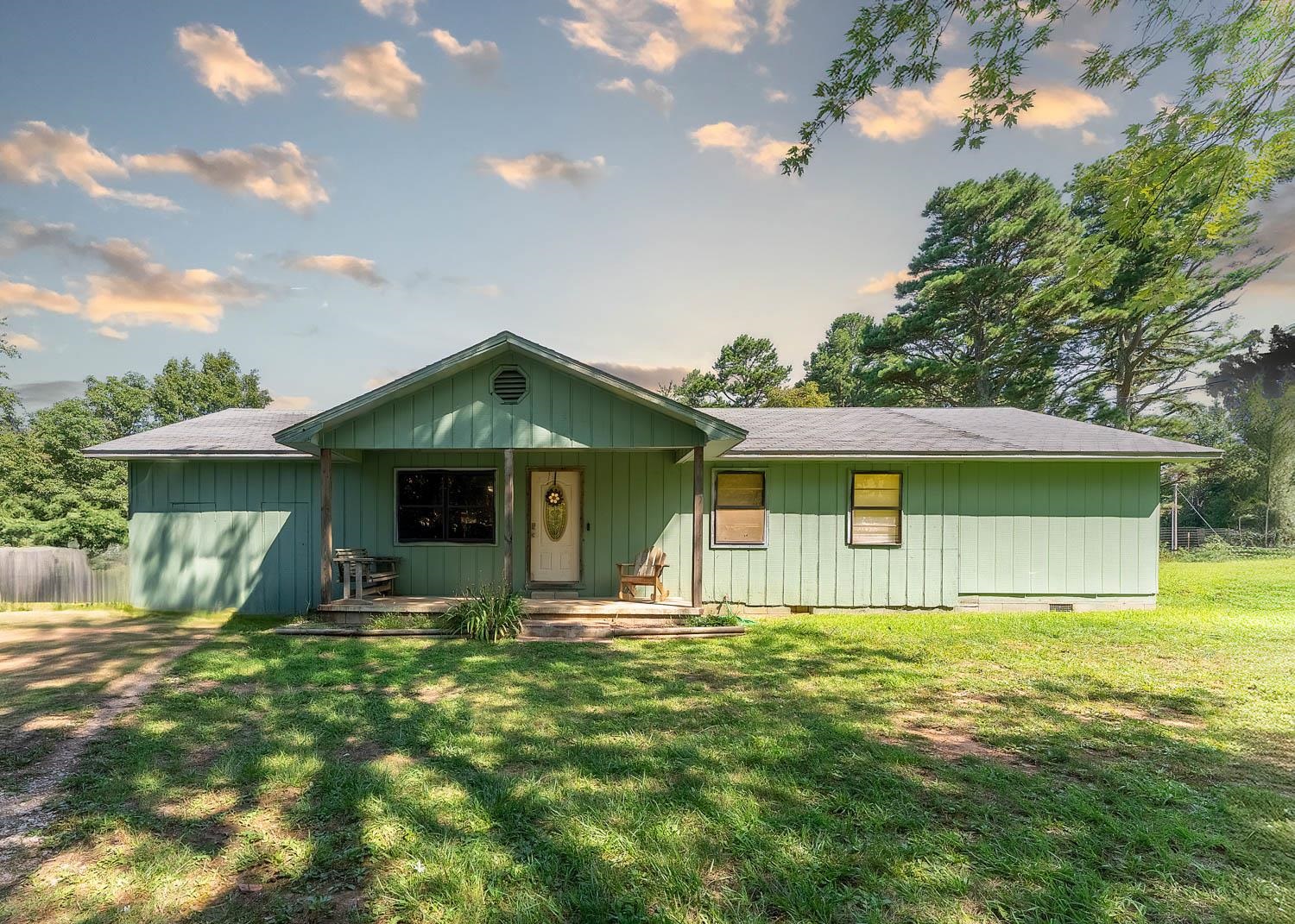 This charming 3-bedroom, 1.5-bathroom home is perfectly situated on a picturesque 2.72-acre lot, offering a harmonious blend of peaceful country living and modern updates. As you step inside, you'll be greeted by an inviting open-concept layout that seamlessly connects the kitchen, living, and dining areas. This design is ideal for family gatherings, casual entertaining, or simply enjoying everyday life in a warm, welcoming space. The spacious master bedroom serves as a serene sanctuary, complete with an oversized walk-in closet that offers ample storage. Thoughtful renovations include new hardwood floors and custom wood countertops, adding a touch of rustic elegance. With all-new PEX plumbing and a brand-new central heating and cooling unit, this home ensures comfort and efficiency throughout the year. Outside, the property truly shines. A large fenced backyard provides a safe and spacious area for kids or pets to play, while the shaded front yard, adorned with mature trees, offers a tranquil spot for relaxation or outdoor gatherings. The property includes two outbuildings and a barn, offering plenty of additional storage or workspace.