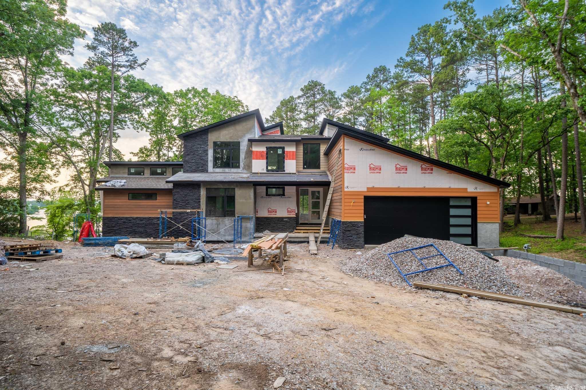 Must see this beautiful brand new construction home that sits right on the main channel of Lake Hamilton! The contemporary design of the home blends perfectly in with the natural surrounding, and the expansive window package captures all of the breathtaking views this property has to offer. Boasting an array of sleek finishes and a thoughtful open plan layout, this immaculate 6-bedroom, 5-bathroom also features 2 kitchens, multiple outdoor living areas (including an outdoor kitchen), a theatre, and more!