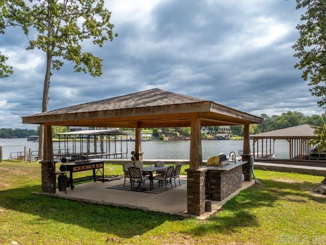 Looking for the perfect lakefront getaway and solid investment? With 100 feet of Lake Hamilton frontage and a new 2-stall covered stationary boat dock, this home has everything you need for fun on the water and the fabulous outdoor kitchen offers the perfect setup for lakeside gatherings. Inside thereās room for everyone with 4 bedrooms (each with lake view), 2.5 baths and a bonus/bunk room that could easily be converted to a game room. Plus, the detached garage has been converted into additional living space that sleeps 6 with a kitchenette and full bath ā perfect for additional guests or a private retreat. Currently used as a short-term rental and offered fully furnished, this property is already set up to generate income while providing you the perfect spot for your own vacation days. Whether youāre looking to invest or simply enjoy lake living, this one is a win-win! The adjacent lot with 98ft of lake frontage is also available for purchase and already has a boat dock.