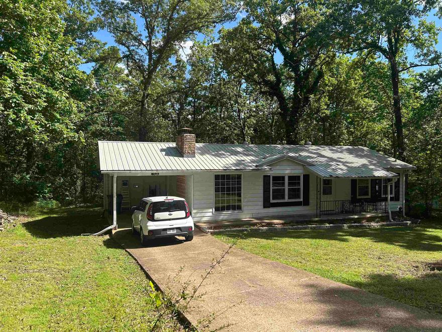 Nice move-in ready 2 bedroom bath and a half. Pretty laminate flooring with newer carpet in both bedrooms. It has central heat and air with anew fan installed this year. There is a site bult wood burning fireplace ready to snuggle up to on a cold winter night. The metal roof was put on in 2023 with many years of life left. Ample closet space for all your clothes and shoes! There is a sunroom enclosed, heated and cooled which is a great office area or additional space for entertaining! New refrigerator, sink and dishwasher. The newer washer and dryer stay and makes your move much sweeter! Wooded lot with a storage building in the back yard and a termite contract for your protection. Pretty flowers and plants adorn the front yard. When you purchase this home you will have access to 7 lakes, 2 award winning golf courses, a river, swimming pools, entertainment centers and all the luxury that high end properties have without the high end price! Make this yours today. Priced to sell at $129,900.00.