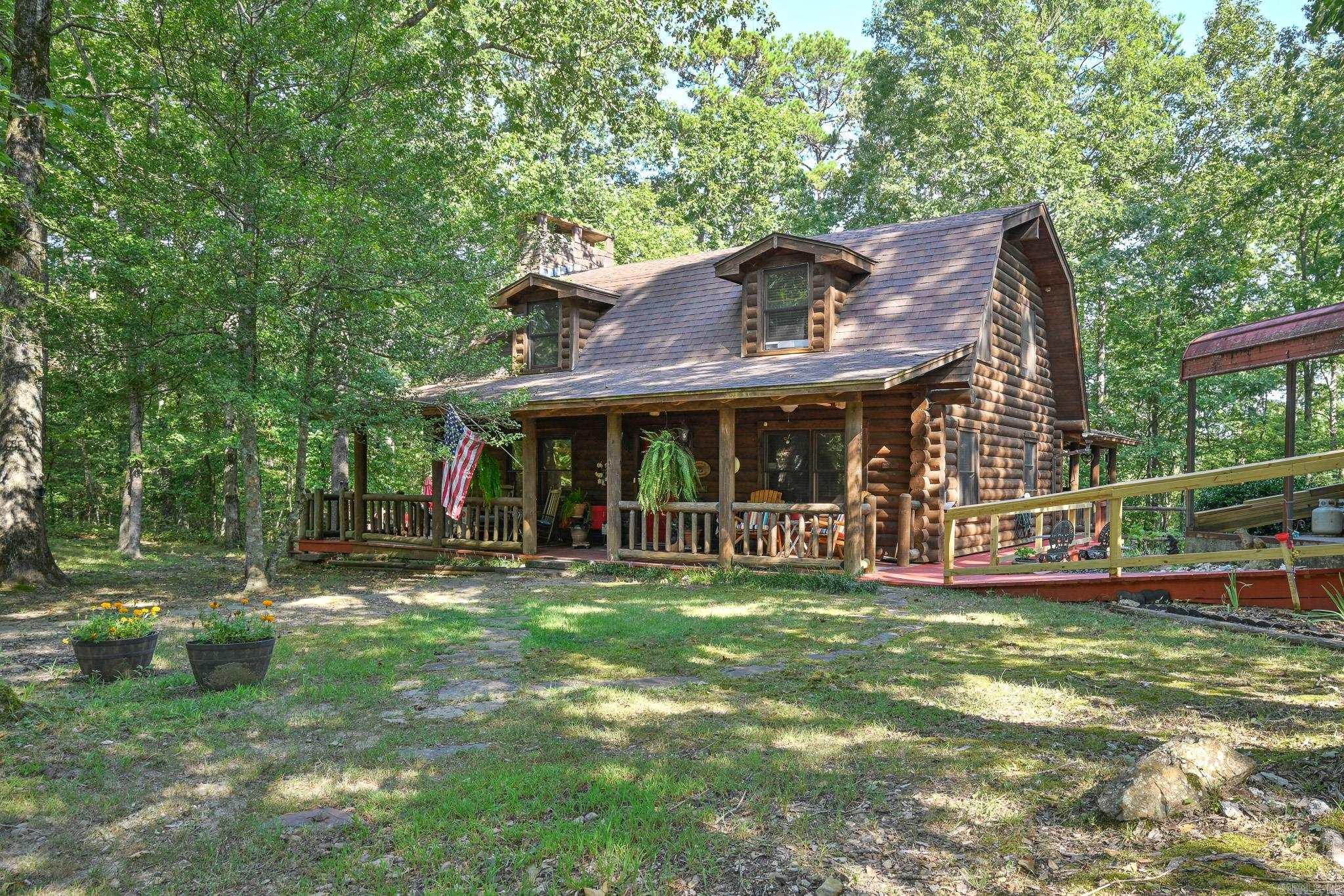 Escape to your own private paradise in Vandervoort, Arkansas! This Stunning log home, crafted from 10" pine logs from Heritage Log Homes in Tennessee, offers a perfect blend of rustic charm and modern luxury. Situated on 4.54 acres of pristine, wooded land, this property promises tranquility and seclusion. Step inside the main level and feel the warmth of the ambient heated floor system. The home boasts four spacious bedrooms, three full bathrooms, and one convenient half bathroom. An additional full bathroom is located in the well house, perfect for an RV guest space. The interior showcases Beautiful Stonework, including a Magnificent Site-Built Fireplace, the centerpiece of the living area. Multiple porches provide ample space to enjoy the outdoors, and one even features a relaxing hot tub for unwinding under the stars. The property is equipped for all your needs, with a 40' x 18' carport designed to accommodate an RV and a separate 25' x 30' carport for two vehicles. This unique and meticulously crafted home is a true sanctuary, offering a lifestyle of comfort and natural beauty. Don't miss this opportunity to own a piece of Arkansas heaven!