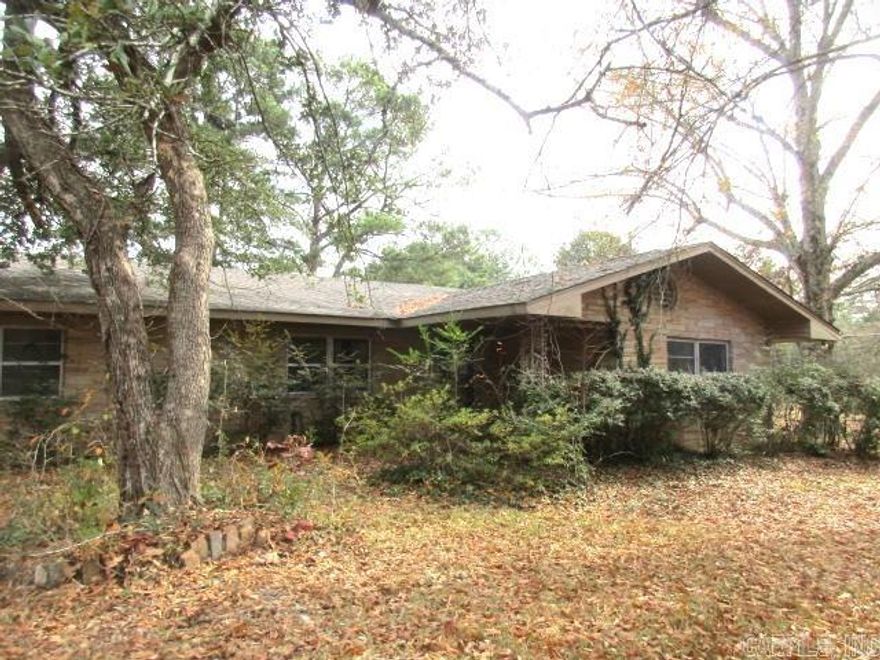 Don't miss this jewel!!  This 3 bedroom, 2 1/2 bath home sits on 5+ acres with a pond.  This home is just inside the city limits.  Two living areas, sunroom, and detached shop/carport, large bedrooms.   Beautiful crown molding in the living room and dining area.  Carport on back of home.  Beautiful crepe myrtles line the front of the property. Call today for your personal tour and details on this home. Taxes are before Homestead Credit **Agents See Remarks**