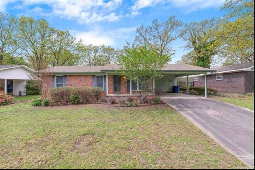 Charming brick ranch on a spacious, tree-lined lot in North Little Rock! This well-maintained 3BR/2BA home offers an open living, dining & kitchen layout perfect for everyday living. The oversized living room features hardwood floors, a wood-burning fireplace & large picture window with abundant natural light. Kitchen boasts white cabinetry, granite countertops, tile backsplash & stainless steel appliances. All bedrooms include hardwood floors & ceiling fans. Third bedroom works beautifully as a home office or guest suite. Both bathrooms updated with marble-look countertops & classic white tile. Enjoy the expansive fenced backyard with mature trees & concrete patio — ideal for pets, play & entertaining. Covered carport adds convenience. Move-in ready & full of character — this one checks all the boxes!