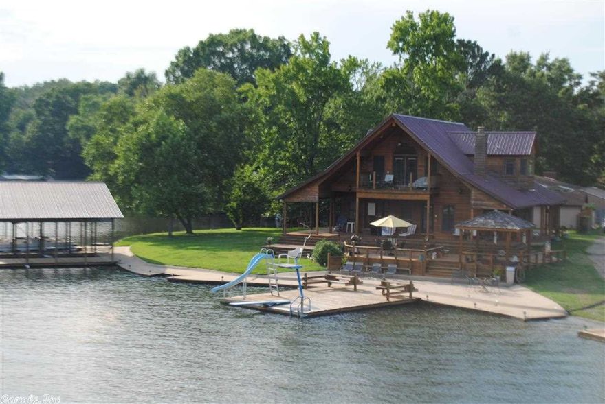 Lake Hamilton Point near Blakely Dam offers  789 ft of shore line with concrete seawall, boat ramp, an incredible Lighthouse, 2 stall boat dock, a swim dock , a fishing dock, a party deck w/hot tub . This 3/3 Custom cedar home built to enjoy the water has a wrap around porch that includes surround sound , beautiful hard wood floors and vaulted ceilings , granite, the master suite-retreat has its own private balcony w/ an unobstructed view up the main channel ! A must see !