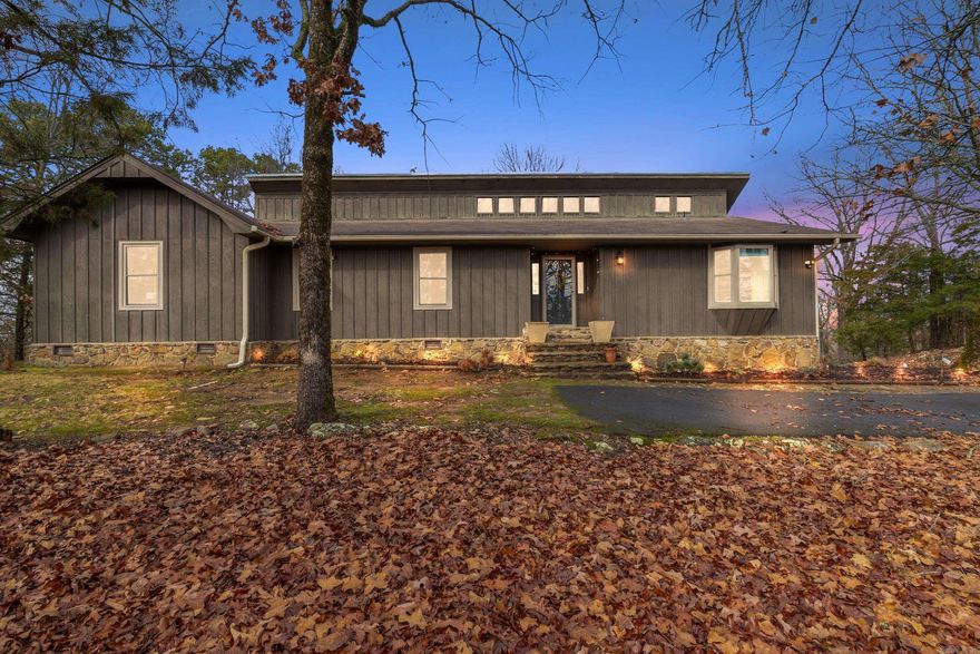 Beautiful contemporary home in a peaceful wooded setting. With views of Lake Beaverfork in the winter, and a park-like setting year round, this home is an outdoor entertainer's dream. From the large back deck, to trails, to the fire pit, there are many ways to enjoy nature at this property. Inside, you'll find a remodeled home with tons of character. The kitchen is light and airy with tall ceilings and natural light. The living room has a cozy feel with a stunning painted rock fireplace, wood mantle, and gray accent wall that ties the room together. Vaulted ceilings in the primary suite with a private door to the deck that overlooks the forest and Lake Beaverfork. The other bedroom's are large, with 3 bedrooms total upstairs. Updates include new paint in most rooms, new flooring downstairs, new light fixture in dining room, and all new stairs. Downstairs you'll find another living area, bedroom, bath and laundry. The home also features a large shop/hobby area with access from the downstairs. Great location.  Just 10 minutes from downtown Conway, but feels like you are far away from the city.