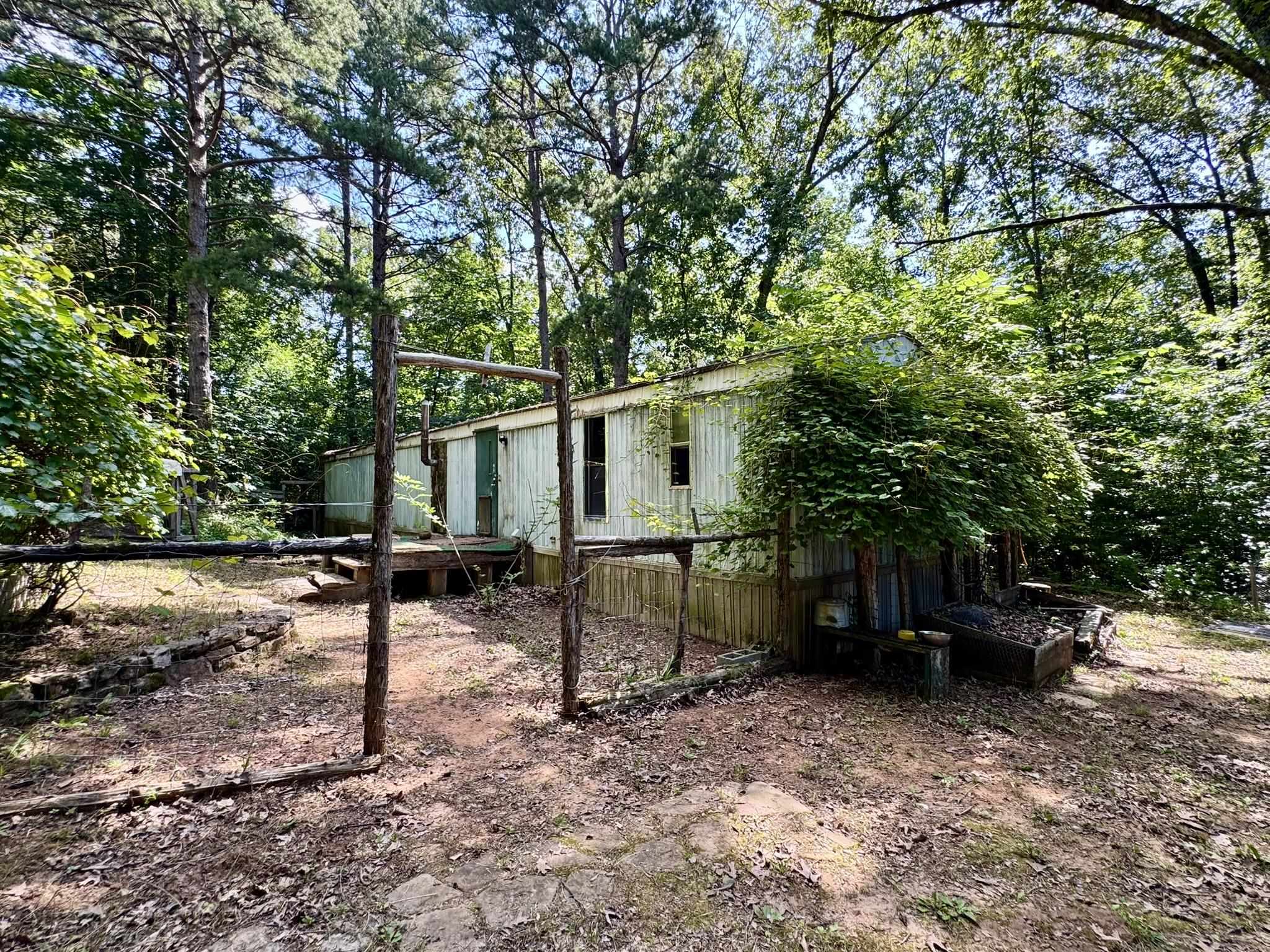 Private retreat on a year round creek with a 2-bedroom, 2-bath mobile home on 13 acres. This property features a secluded location surrounded by mature trees with easy access down to the creek. The home features an open floor plan. Both bedrooms are great size with the primary bedroom having an attached bathroom. Outside the home is a workshop, storm shelter, old barn, & trails down to the creek to explore! Whether you're looking for a full-time residence or weekend getaway, this property offers endless potential.