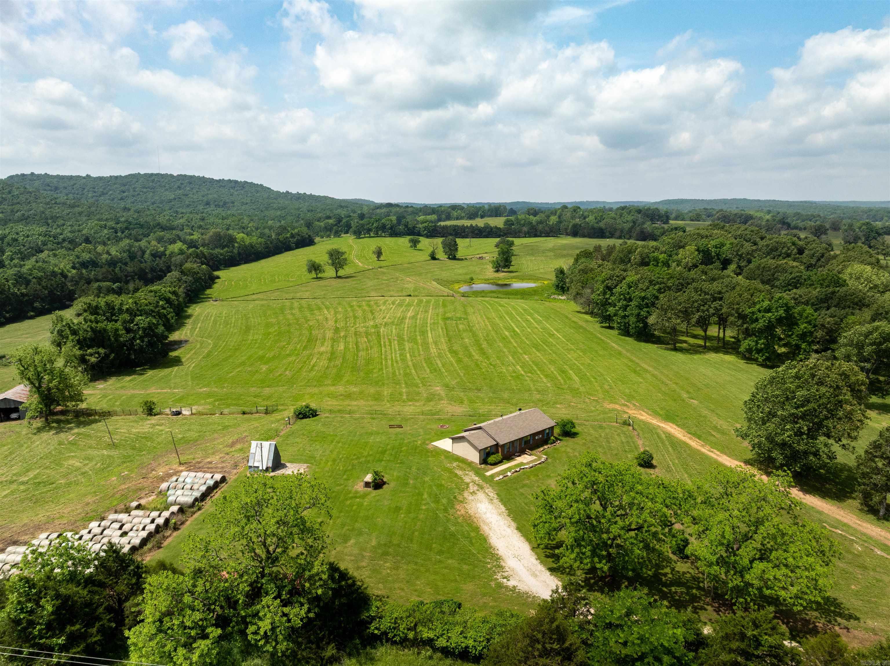 Farm with Breathtaking Views, Springs, Ponds & Multiple Home Sites – 145 +/- Acres From the moment you pull onto this beautiful farm, you’re greeted with stunning views from the brick home, perfectly situated at the front of the property. The home offers approx. 1,161 sq ft with a newer roof and HVAC system (less than 2 years old). Built on a concrete slab, it features a cozy layout, back patio, and is move-in ready with just a touch of TLC. Utilities: Grange Calamine water, North Arkansas Electric, and fiber internet already in place! Spring-fed Option: Property was once hooked to a spring, still flowing strong—offering the option to switch to spring water if desired. Land Features: Fenced & cross-fenced with hay fields 2 ponds + 2 live springs Working cattle corral Frontage on Highway 354 (paved) & Shiloh Rd (gravel) Bonus Homesite: On the backside, there's a separate setup ready for a second home, mobile, or modular—ideal for multi-family livingwith privacy! This land is truly turnkey for cattle, ready for horses, and could easily be adapted for sheep or goats. A versatile farmin an excellent location just outside Ash Flat, Arkansas—perfect for a family!