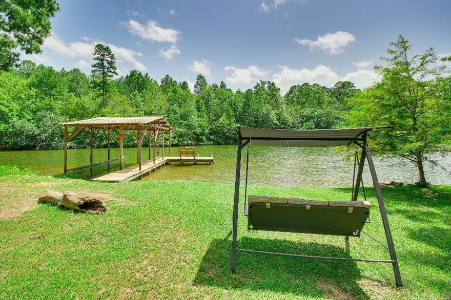 LAKEFRONT PARADISE FOUND! This 4 bd/3 ba home offers an amazing opportunity for lakefront living! UPPER level: 1bd/1ba open floor plan & breathtaking view of Lake Hamilton from the dining rm to the large kitchen enjoy unobstructive water views in a quiet cove off the main channel. Vaulted cedar ceiling, gas fireplace. 2 sliders open to covered deck w/BBQ.  LOWER LEVEL: Private entrance to cottage-like living: 3/2 w/kitchenette & LR.  Bedrooms open to porch w/Hot Tub. Private dock/boat slip. Currently STR