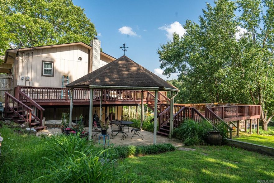 This beautifully updated 3/2.5 exudes craftsmanship, quality, and care. Upon entering the open-concept living space, you will immediately see examples of special touches and quality, including solid bamboo flooring, exquisite millwork, upgraded lighting, and stainless appliances. This home was once owned by a craftsman who outfitted the home in extravagant woodwork from built-ins to cabinetry to moldings to a custom staircase. The downstairs game room comes ready for fun with a big-screen TV, AV equipment, and a pool table! There are not one but two outbuildings on the property. The 26'x24' shop has a separate meter and was formerly used by a cabinetmaker. The 13'x40' building is used for boat storage--155 Enterprise is a quick 2.2 mile drive to Hill Wheatly Park's public boat launch! This lovely property is on a corner lot and offers as much to enjoy outside as inside with its beautiful landscaping, expansive decking, a gazebo, and a large lawn. So much to offer and so many memories to be made. [New roof in 2023 and HVAC unit serviced regularly by Grisham Heating & Air and Pella Windows]