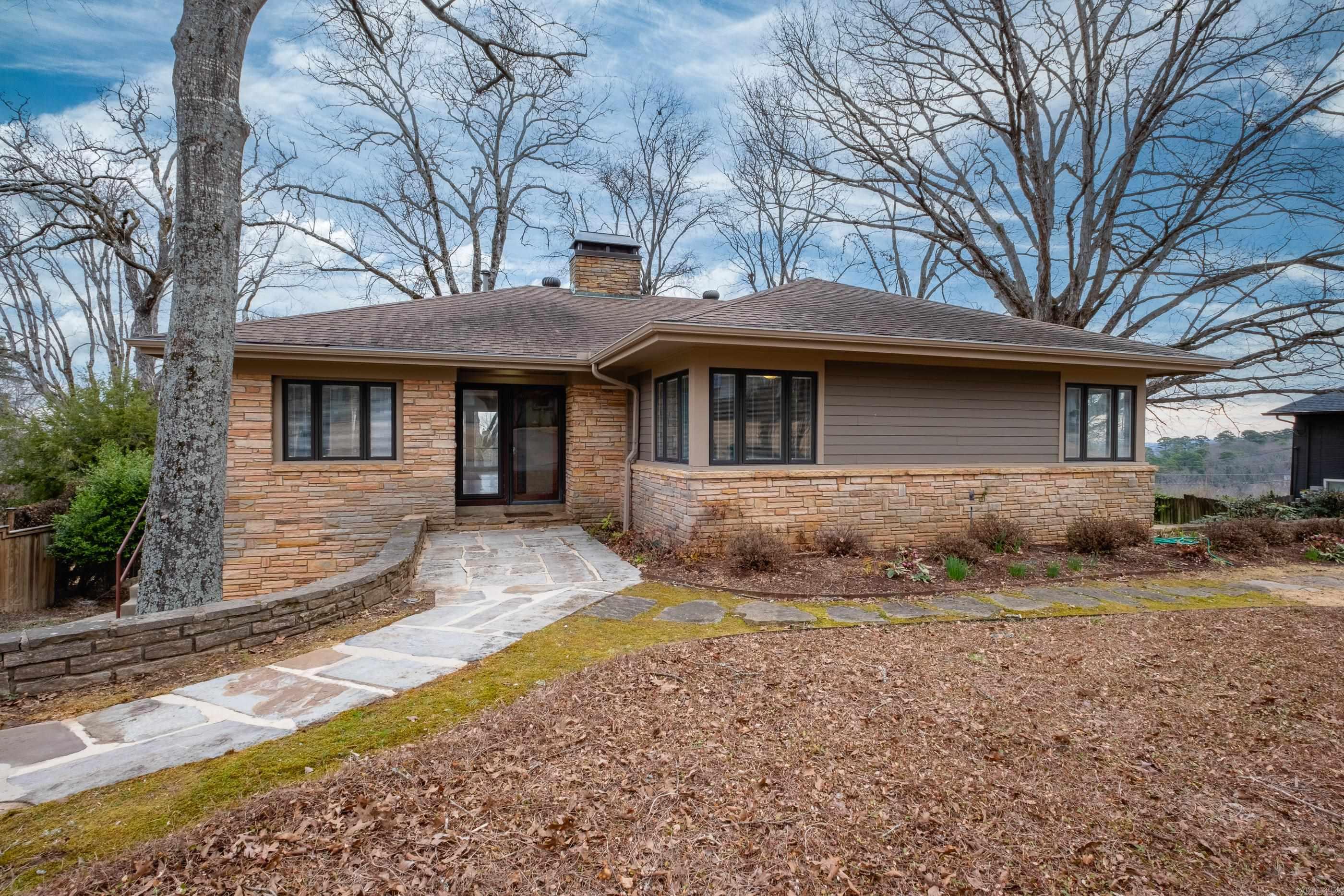 Imagine having this stunning river view from your home every day! No matter the weather you can enjoy the tranquility of being home with floor to ceiling windows and ample space perfect for entertaining. This architectural jewel is on one acre of land, in the heart of LR and on the market for the first time! Constructed and owned by a family of engineers with Pella windows and doors throughout. Open Living and Dining areas with hardwood floors leading to deck overlooking the backyard. Primary suite, two bedrooms and a full baths on main level. Down a wide stairway you will find additional living area with beautiful original stone fireplace along w/ two bedrooms, two baths, Game Room with full kitchen. Perfect apartment/living quarters for elderly or children. Incredible views from the beautiful decking and tiered backyard. Agents see remarks.