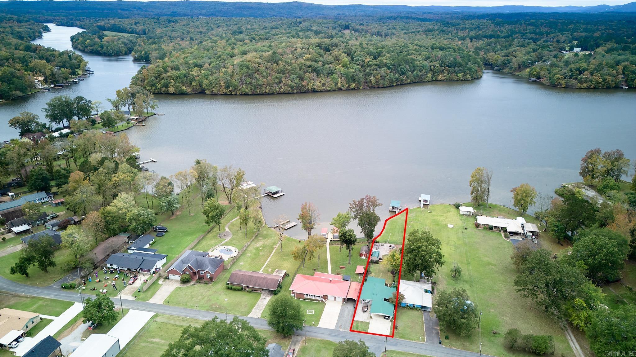 Welcome to this beautifully updated lakefront home offering breathtaking views and a private fixed steel boat dock located on a flat half acre with 160ft of shoreline   - perfect for enjoying life on the water. Every detail has been thoughtfully refreshed, including new paint throughout, all new lighting, new hardware, top of the line applicances, new stylish kitchen backsplash, granite counter tops, bathroom vanity and a gas tankless water heater. Step inside to find an open layout with laminate flooring and a vaulted ceiling that enhances the spacious feel. The large primary bedroom provides a relaxing retreat and features a spacious closet. The sunroom is surrounded by windows offering incredible lake views and functions as multiple areas, whether for dining, relaxing or entertaining. Enjoy outdoor living at its best with a covered back porch, outdoor shower and extra landscaping including blueberries, strawberries, lavender and more, all designed to take in those stunning sunsets.  A two and a half car carport with overflow gravel parking spots, adds convenience and space all while the location close to the interstate is ideal for shopping or dining. See Agent Remarks.