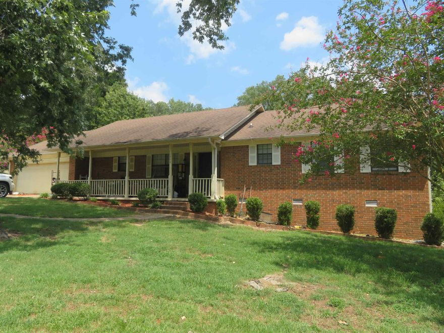 TRADITIONAL, 1-Level, BRICK HOME with nearly 1,800 sq. ft., heated/cooled --- PLUS an 8' x 32' covered FRONT PORCH & a DOUBLE GARAGE WITH STORAGE/SHOP AREA measuring a total of 21' x 29'.  And there is a HUGE SCREENED PORCH on the rear (East side) of the house measuring nearly 10' x 32'!  This screened porch COULD BE enclosed with windows and/or exterior siding --- & install a subfloor with hard-surface flooring (presently has a treated-pine, deck floor).  A Buyer MAY WISH to make this area heated/cooled.  There is also an open-air, smaller deck (approx. 12' x 12').  This residence is ON A CORNER LOT and the most recent occupant required additional off-street parking --- so there are 3 ADDITIONAL, GRAVELED AREAS for 'EXTRA PARKING'.  The interior is mostly newly painted (pale grey & white) and has new, 'waterproof' Vinyl Plank Flooring in shades of gray.  The kitchen has lots of custom-built cabinetry, an adjoining/adjacent CASUAL DINING AREA, and a separate LAUNDRY ROOM and HALF-BATH.  Large LIVING/DINING COMBINATION (with doorway to huge, 'screened' porch).  There are 3 BEDROOMS & 2 BATHS (plus the half-bath).  Newer Architectural Shingles installed less than 10 years ago.