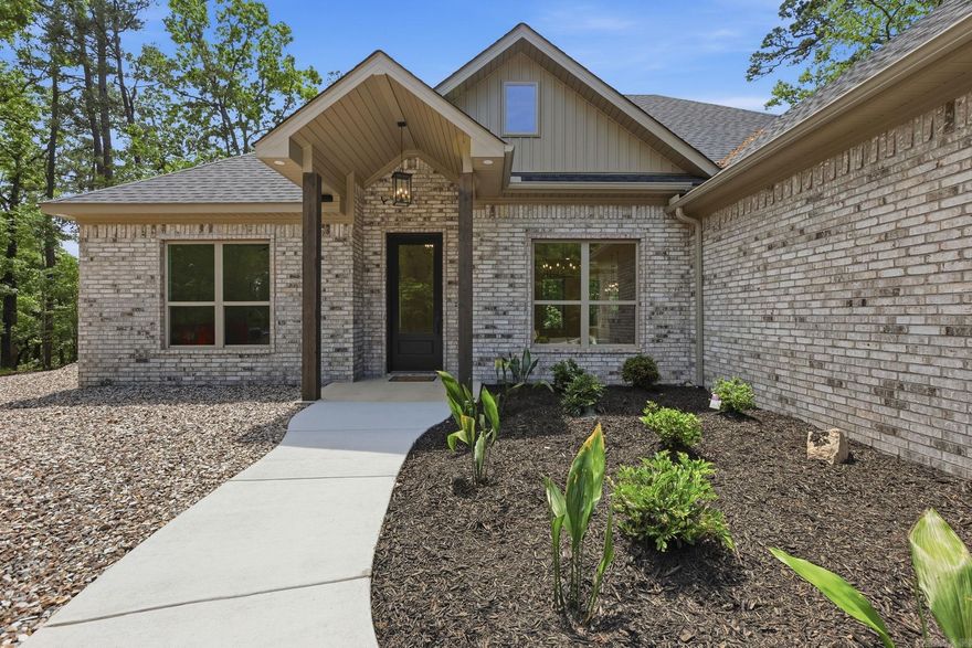 New construction modern home in Hot Springs Village featuring 3 bedrooms, 2 baths, and desirable one-level living on a flat lot. This all-brick home offers a bright open floor plan, split bedroom layout, and stylish finishes throughout. The kitchen features quartz countertops, custom cabinetry, stainless steel appliances, and a large island overlooking the living and dining areas. Spacious primary suite includes a walk-in closet and beautifully finished bath. Enjoy privacy and peaceful surroundings with low-maintenance exterior and energy-efficient construction. Ideal for full-time living, second home, or investment property. Located in gated Hot Springs Village with access to 11 lakes, 9 golf courses, walking trails, pickleball, tennis, dining, and more. Move-in ready with modern design and quality craftsmanship throughout.