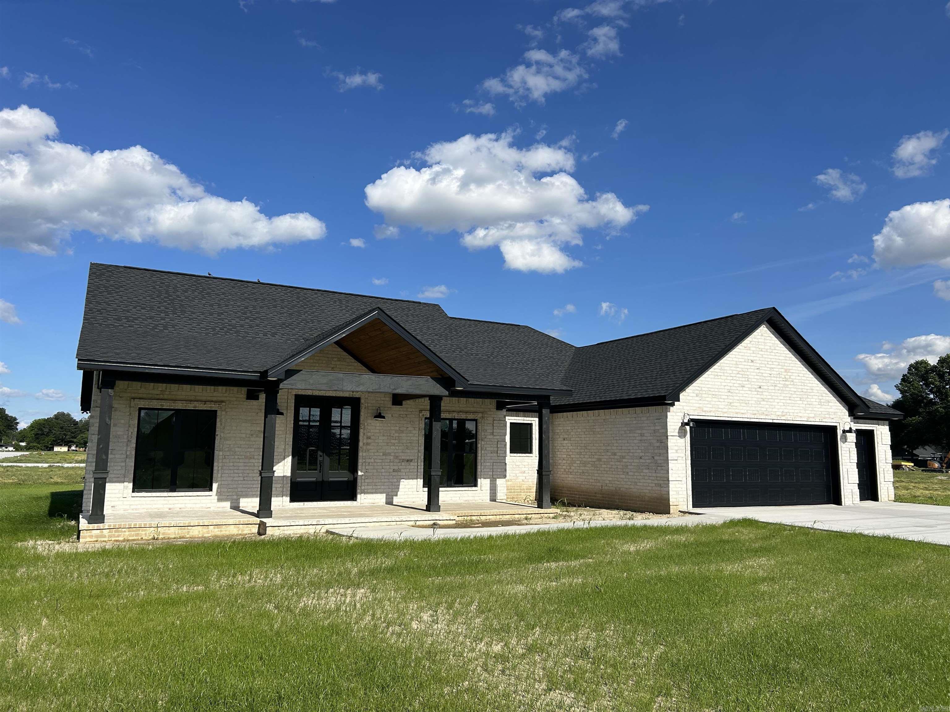 Welcome to this beautifully crafted 3-bedroom, 2.5-bathroom new construction home, perfectly situated on a spacious .42-acre lot in the heart of Trumann. As you step inside, you'll immediately appreciate the seamless flow between the living, dining, and kitchen areas. The heart of the home is the kitchen, featuring sleek granite countertops, custom cabinetry, and an inviting island, ideal for meal prep or casual entertaining. The luxurious master suite is a true retreat, offering a spa like experience with a walk-in shower, a relaxing jacuzzi tub, and a large master closet providing ample storage space. The two additional bedrooms are generously sized and perfect for family or guests. This home also offers a 2-car garage with an added bonus of a third garage space, perfect for storing your golf cart or extra recreational gear. Outside, the expansive .42-acre lot gives you plenty of room for outdoor activities. This home is located with easy access to local amenities such as Walmart, Dollar Tree, McDonalds, the new Shadrach's, and the new La Cascada Mexican Restaurant coming to town. Don't miss the chance to make it yours, schedule your private tour today!