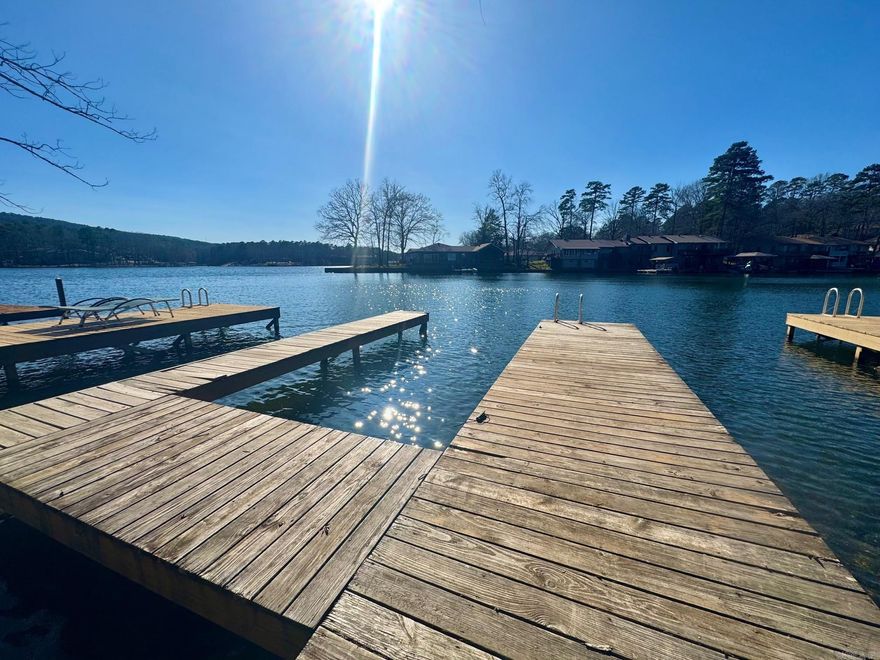 Steps to Lake off back porch with your own private boat dock! 2023 updates: new paint, new shower/bath, new LVP flooring throughout main living and bedrooms, new carpet for the stairs. Enjoy lake life with an upper and lower deck option!  Both bedrooms on bottom floor, one with walkout to Lake DeSoto. Lake stays high ALL year long! Kayak, swim and hike by walking out, enjoy 9 golf courses and 11 lakes of HSV, 30 minutes from Oaklawn and downtown Hot Springs.  2nd home, investment airbnb, or primary, you choose!