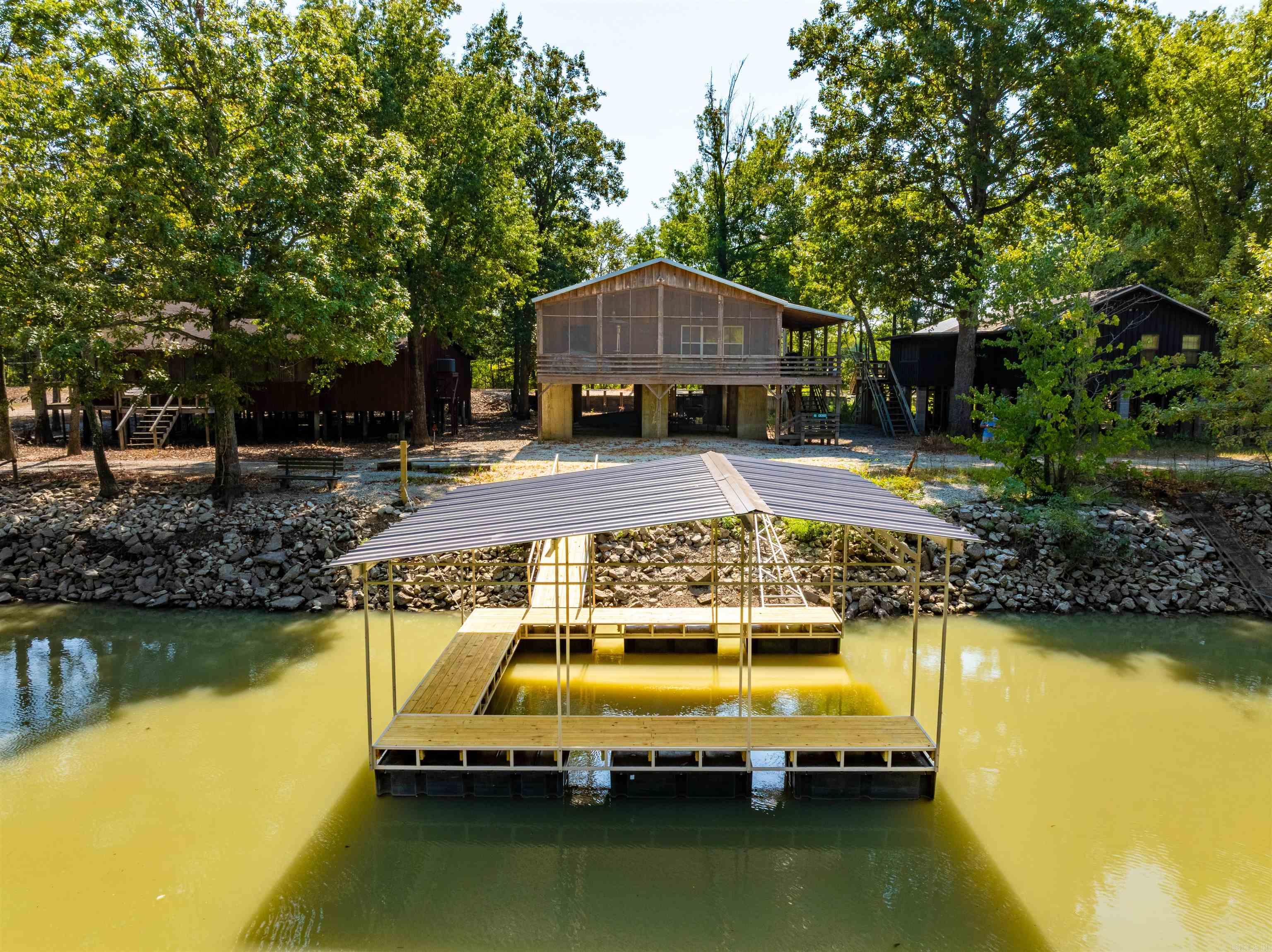 Black River duck hunting cabin with private dock—Brookings, AR. Skip the ramp lines and be in Dave Donaldson/Black River WMA in minutes. Turnkey 3BR/2BA (1,536 +/- sq ft, built in 2015) with spray-foam insulation, metal roof, large kitchen w/ island, wader/mud room, storage room, and laundry. Furnished (major items convey). Full-length screened back porch overlooks the river & WMA; covered front porch. Under-cabin storage, boat parking, space for dog pens. Per seller, never had water inside. Surrounded by AGFC lands in Mallard Point/“Quacker’s Alley.” Address: 46 Clay County Rd 2003, Peach Orchard, AR.