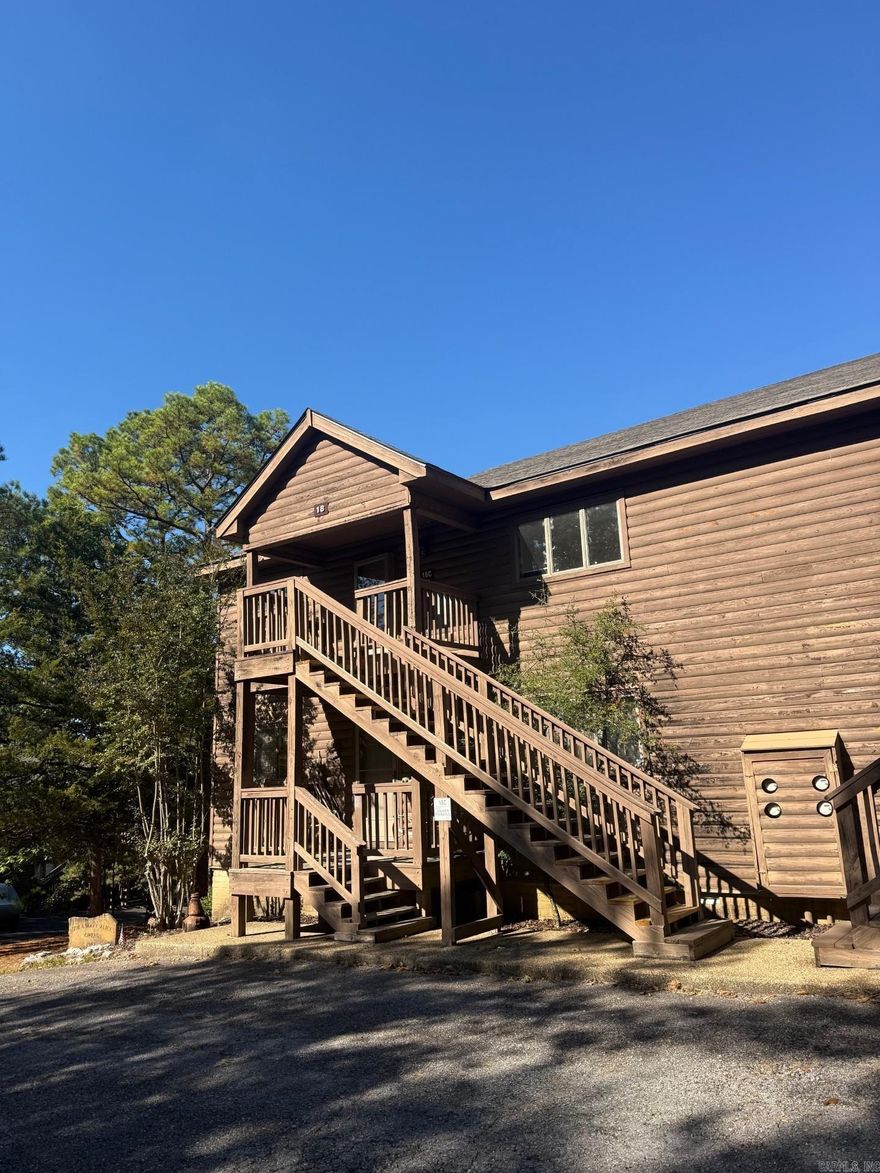 Step into this beautifully updated second-floor condo just minutes from Lake Ouachita. This move-in-ready property offers a light-filled living area with vaulted ceilings, a cozy fireplace, and numerous windows that bring the outdoors in. The kitchen features new cabinets, countertops, appliances, and an ice maker. The bathrooms have all new fixtures and showers. Fresh paint, new flooring, and new lightening flow throughout the home for a clean, modern feel. Enjoy the peaceful wooded views from the balcony, accessible from both the living room and the primary bedroom. All of the new furniture, TV's, and Blackstone conveys making this an ideal full-time residence or weekend retreat.