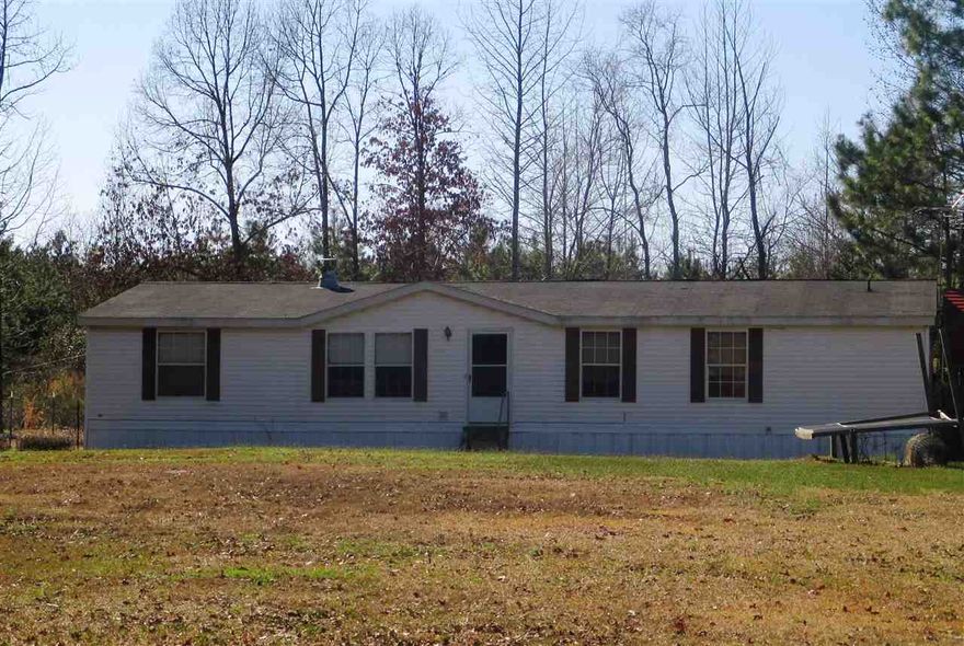 Great home with vaulted ceilings, split floor plan, large kitchen, woodburning fireplace, office, laundry room, large master bathroom with garden tub, walk in closets, and lots of storage.  The refrigerator and washer and dryer all stay with the home.  Large carport for parking at side entrance.  Older home behind double wide makes a great shop or could be used for storage.  This home is on a permanent foundation.  **Solar Panels do not convey**  Call today for your personal tour.