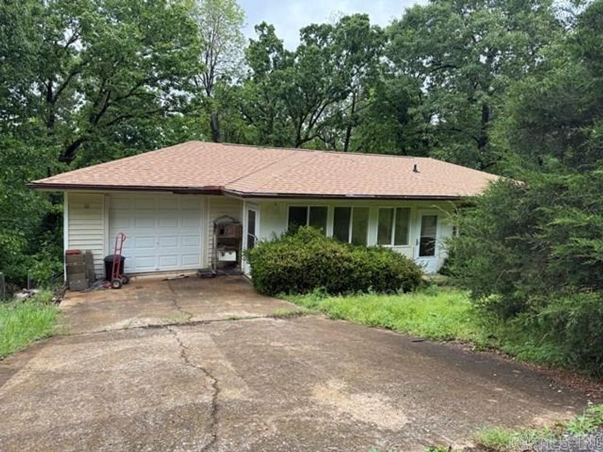 This home sits on a large lot and a functional single-level layout that offers significant potential for the right buyer.   This two-bedroom, two-bathroom home requires renovation but offers solid investment potential. The attached garage provides covered parking, while the existing deck creates outdoor space ready for restoration. Comprehensive updates will be needed throughout to realize the property's value.   Located on a private wooded lot between Lake Paradise and Lake Omaha, the property sits near Cherokee Village South Golf Course. The forested setting delivers seasonal foliage panorama views and clear starry night sky vistas from this secluded position.   The property needs significant work throughout, creating an opportunity for complete transformation while capitalizing on the dual lake access and natural privacy that the wooded lot provides to future owners.   Call today to schedule your showing and evaluate this home's renovation potential and solid foundation for your next project.
