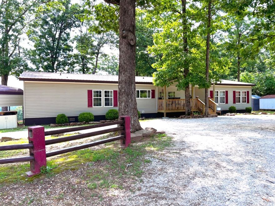 Scenic Retreat Near Mountain View, AR. Nestled just 15 mins from town, this spacious 4-bed/2-bath, 2,240 sq ft manufactured home (2006) sits on 5 beautiful acres w/stunning views of the surrounding mountains and valleys. Home features a split floor plan w/large master suite, complete with dual walk-in closets, a garden tub, & private bath. The open-concept kitchen/dining combo connects to a spacious living area, making it perfect for gatherings & everyday living. Step outside & experience the lifestyle this property offers: a custom horseshoe pit, a gathering circle w/firepit & outdoor movie screen, & a private hot tub enclosure (hot tub does not convey), all take full advantage of the scenic, sloped wooded lot. You’ll even find a unique “trail tree” marking your path into the natural beauty of the Ozarks. Utilities include public water, municipal electric (Entergy), a & private septic system & a torando shelter. With proximity to the White River, Ozark National Forest, dining, shopping, & Mountain View's music-filled charm, this property offers peace, privacy, & potential — whether for a full-time residence, getaway home, or vacation rental opportunity.