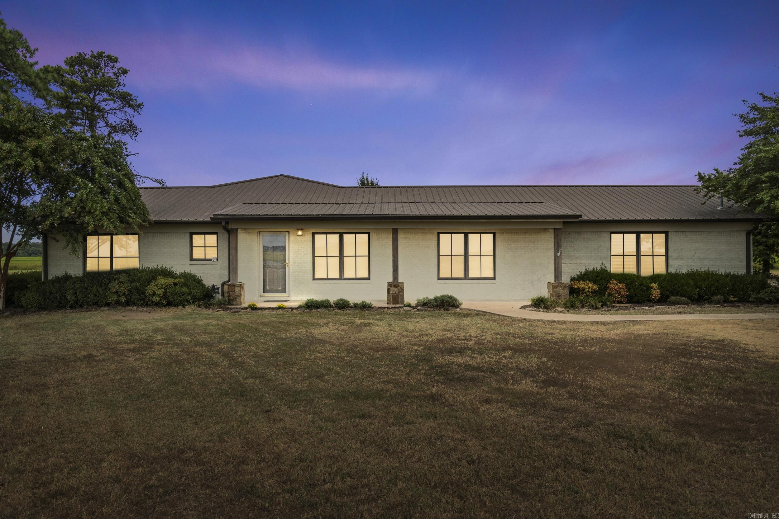 Southern Charm with Modern Comfort! This stunning property sits on 2.94 acres in the sought-after Cross County School District. The chic home features 4 spacious bedrooms, 3 full baths, and expansive living areas centered around a grand stone fireplace. With double primary suites, the floor plan is versatile and offers privacy for everyone. The updated kitchen shines with an island, side-by-side full-size fridge and freezer, and abundant storage. Large, high-end windows flood the home with natural light. Both primary suites boast attached baths with tiled walk-in showers and modern fixtures, while all bedrooms feature custom walk-in closets. Perfect for entertaining, the home offers a formal dining room, eat-in kitchen, expansive decks, and a covered patio—ideal for “chillin’ and grillin’.” Extras abound, including a whole-home generator and a built-in storm shelter beneath the garage. Across the lot sits a rare bonus: a 50x60 metal shop, fully insulated and finished with electrical, plumbing, multiple overhead doors, and a half bath. Two interior rooms are fully finished with HVAC—perfect for an office, hobby space, or guest quarters.luxury, functionality, and space! MUST SEE!