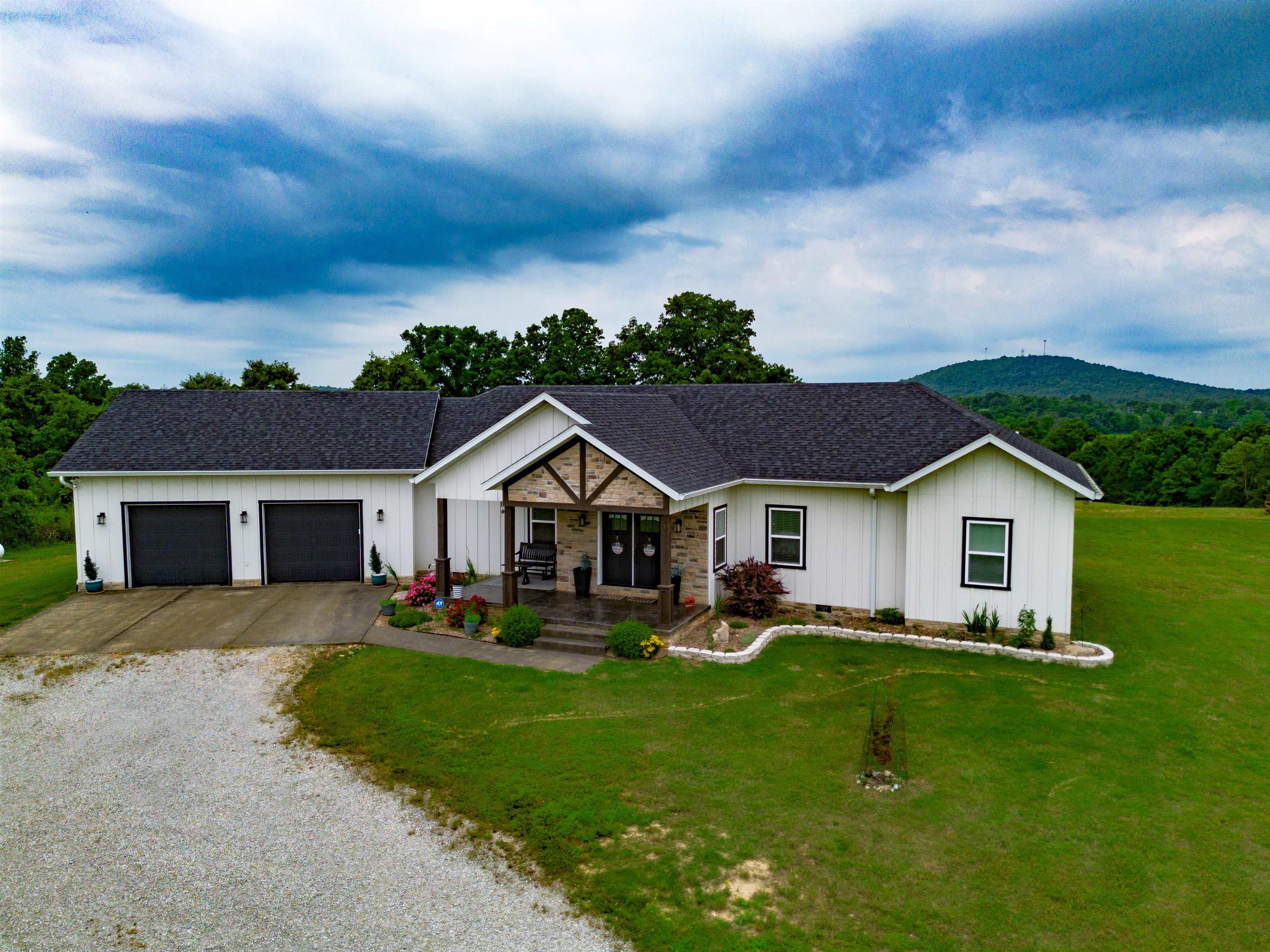 Discover this luxury custom-built country home at 633 Hunter Cemetery Road, Salem, AR. Completed in 2020, this 3,000+ sq. ft. residence sits on 14.16 acres with year-round panoramic Ozark Mountain views. Inside, find 4-5 beds, 4.5 baths, high-end finishes, and an open-concept living area with vaulted ceilings and a gas fireplace. The gourmet kitchen boasts quartz counters and stainless steel appliances. The master suite offers a spa-inspired bath and a second fireplace. The finished walkout basement features a wet bar, home theater, and additional bedroom/bath. Smart home integration, a new roof (2022), and a high-capacity heat pump are among modern conveniences. Outdoors, enjoy an expansive deck, fenced garden with fruit trees, and approx. 7 acres of open pasture for horses or livestock, plus 7 acres of forest. A 2-car garage provides ample space. Secluded yet minutes from Salem's amenities, and close to Lake Norfork and Spring River for recreation. Experience daily mountain views and peaceful country living.