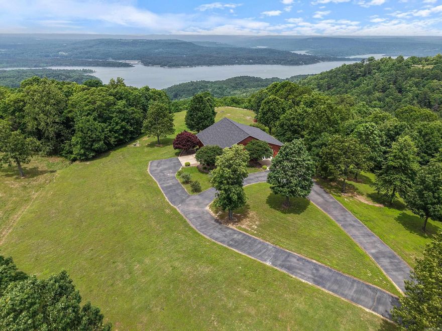 Imagine seeing this breathtaking, panoramic view of Greers Ferry Lake from your very own home on a hilltop point! Every detail of this one-owner home was immaculately planned, and much of it was updated in 2024. As you drive in, there is a 1,500sqft fully insulated garage/shop combo attached to the home. Each story in the home has the ability to be used by a separate group of guests. The main floor of the home features a spacious kitchen, full bath, and a bedroom and living room that both have spectacular views from the windows. The walk-out basement is constructed of insulated concrete (ICF), making it the ultimate safe room, complete with its own living area, bedroom, full bath, and mechanical/storage room. Additional features include quartz countertops, Pella casement windows, and luxury vinyl floors. Want something bigger? Use this home until you build your dream home and you'll have an amazing guest home, as the original owners intended. There is plenty of room on the 13.5 acres, which includes a waterfall you can hear from the porch during wet weather! There is also an additional 25 acres across the road, much of which also has a fantastic view.