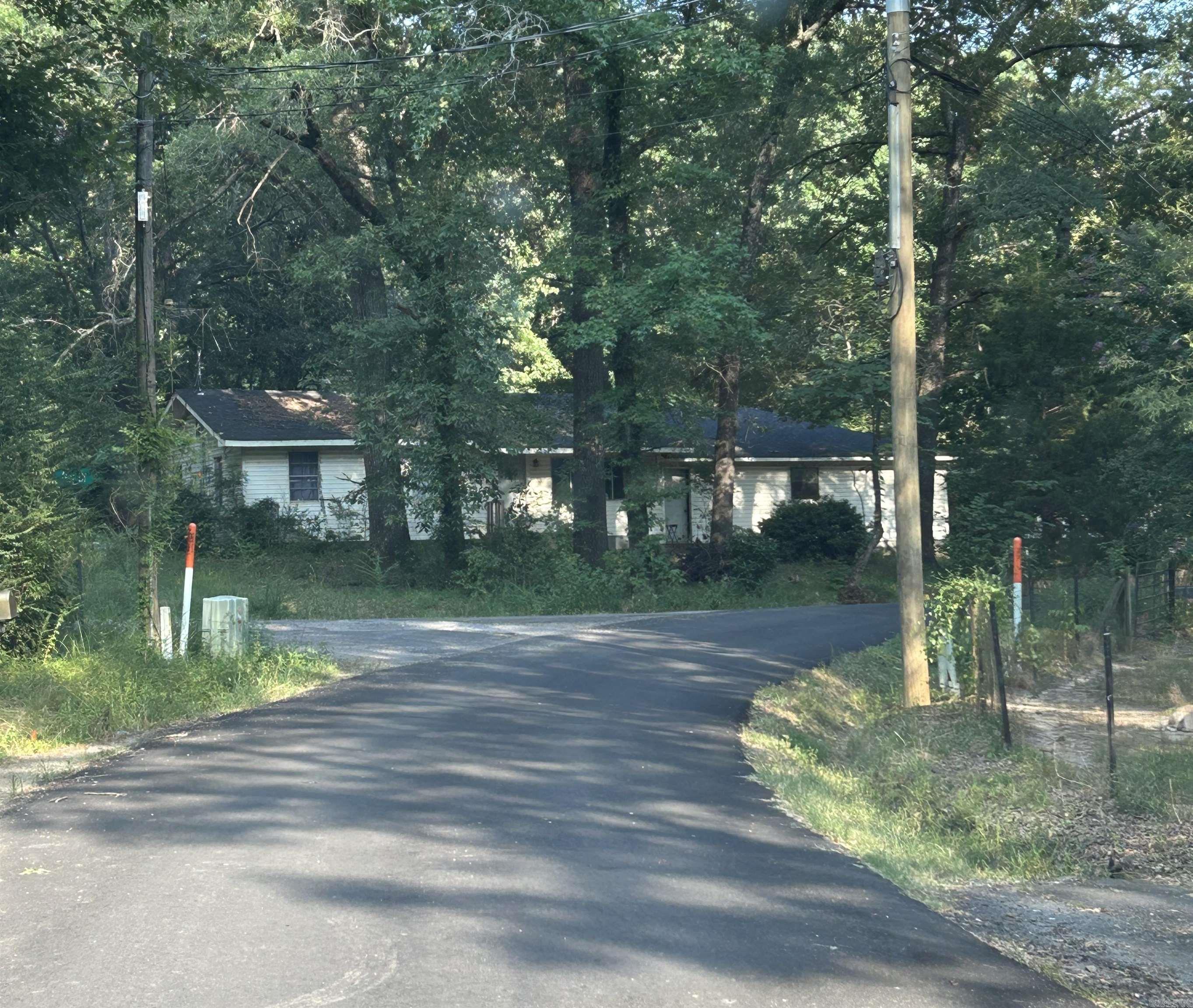 Large, private and shaded lot with lots of potential! 2 bedroom with large bonus room (no closet) in Harris Brake Lake area. Partially fenced, double garage (does not have existing overhead door but opener and rails are installed) and yard shed for extra storage. Solid starter home on .7 of an acre and minutes from public lake ramp! New roof, hot water tank and HVAC system installed in 2020. Minutes from amenities but out of city limits. All hunting dogs and pens will be going with sellers. ** Agents see remarks **