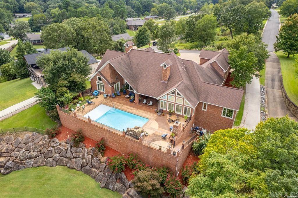 Welcome to your dream home retreat on beautiful Lake Hamilton where luxury and comfort come together in all the best ways. With 6008 square feet, this beauty offers 4 spacious bedrooms, 5.5 baths, and a bonus room that is perfect for a theater, music room or even a 5th bedroom. Step inside and you'll find soaring ceilings, crystal chandeliers, a cozy fireplace, floor to ceiling windows, iconic columns, magnificent kitchen with ice maker, wine fridge, massive double sized fridge freezer combination, all creating the perfect open space for entertaining or relaxing as you take in the unmatched views of Lake Hamilton and the mountains surrounding Hot Springs. As you step outside to the sparkling pool to prepare food in the outdoor kitchen, your guests can further enjoy the easy walk down to your 2 stall covered boat slips for a getaway across Lake Hamilton. Conveniently located close to restaurants, shopping and all the conveniences of town, yet tucked away from all the hustle and bustle, this home has it all when it comes to enjoying lake living. Come partake in your destiny on the water in historic Hot Springs, AR, the Spa City, home of America's first National Park.