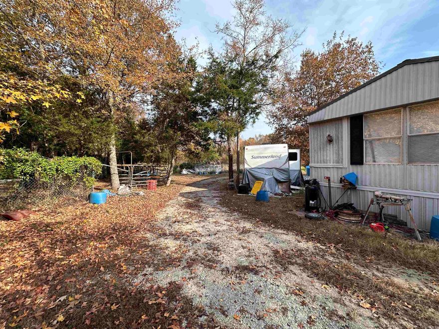 10 +/- Acres with Creek, Mobile Home & Fixer-Upper House – Priced to Sell! If you’ve been searching for a property with land, water, and potential, this one is a rare find. Located on a quiet gravel road, this 10 +/- acre tract features not just one, but two structures, along with creek frontage right in your backyard — a peaceful setting perfect for anyone who loves the outdoors.  The main residence is a mobile home that was in the middle of a remodel when a family tragedy occurred, leaving it unfinished but livable. The hard work has already been started — now it just needs someone to come in and finish it outto make it their own. With a little vision, this could become a cozy country home or an affordable weekend retreat.  In addition to the mobile, there’s an older home on the property that’s full of character and ready for someone with creativity and carpentry skills to bring it back to life. Whether you choose to restore it as a guest house, rental, or workshop, the possibilities are wide open.  The land itself is what truly makes this property special. The yard is open and inviting, surrounded by mature trees, and the creek runs just behind the home, creating beauty.