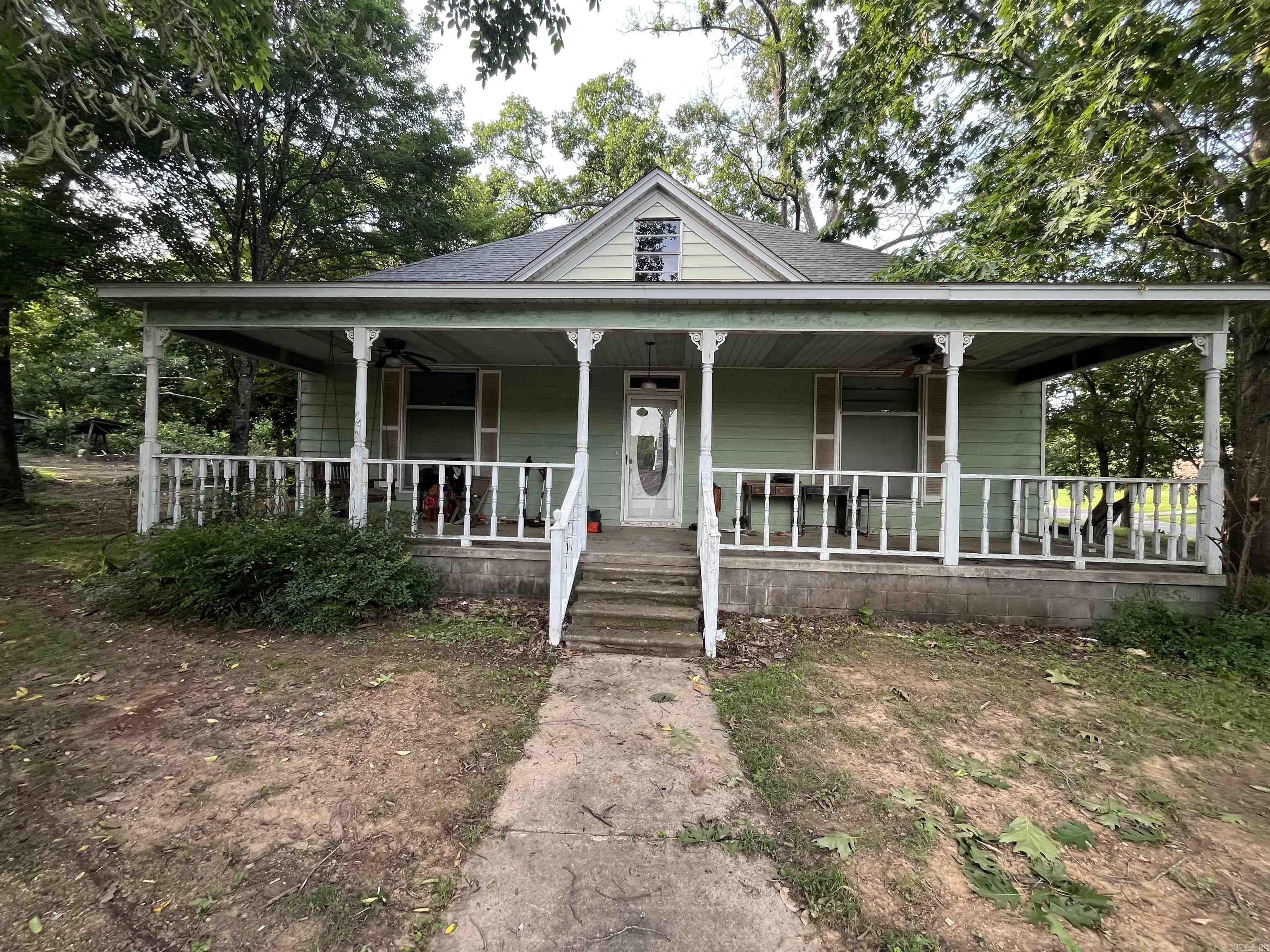 Large Home corner lot built 1898! Offers opportunity for investors, or someone in need of a project. Home has a den with woodburning insert fireplace, large kitchen, formal dining room, formal living room, 3 bedrooms, 2 bathrooms downstairs also a large entry-way with staircase that leads to a full size room upstairs suitable for game room, bonus room or a 4th bedroom. A Large front porch faces the south, large magnolia tree and several pecan trees on the property. The front of property has sidewalk and steps that lead to the street with a rock stonewall (owner states that was built in 1926). Property offers a large carport with storage shed under the carport. Property has metal siding, as well as a side porch that includes a wooden swing for enjoyment. Seller is selling property AS IS will not make any repairs. See Agent Remarks