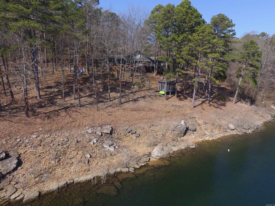 LAKEFRONT - Beautiful lakefront home PLUS EXTRA LAKEFRONT LOT with views of GREERS FERRY LAKE, easy walk to the water, tucked in among the trees & located in a cove across from Damsite Campground, is this private Tumbling Shoals home. This home is move in ready & blends in with the landscape from the lake. Home has 3 bedrooms, 3 baths, large wood burning fireplace in family room & large fireplace in large master suite with gas logs, large deck w/hot tub. Kitchen has nearly new stainless steel appliances, porcelain tile floors, new lighting, new paint & view from kitchen window is terrific! The huge deck overlooking the lake has just been re-stained & is ready for relaxation. There are views of the lake from almost every room & a bonus loft that can be used as office or 4th bedroom. Large garage, could be converted to game room & safe room are heated & cooled, then there's the extra lot to build a guest house or play on when not on the water, plus internet service. With 272' of LAKEFRONT, smokeless fire pit surrounded by rubber mulch, stone walk way with hand rail, screened in gazebo, screened in porch, neighborhood boat launch & picnic area, this is a must see property.