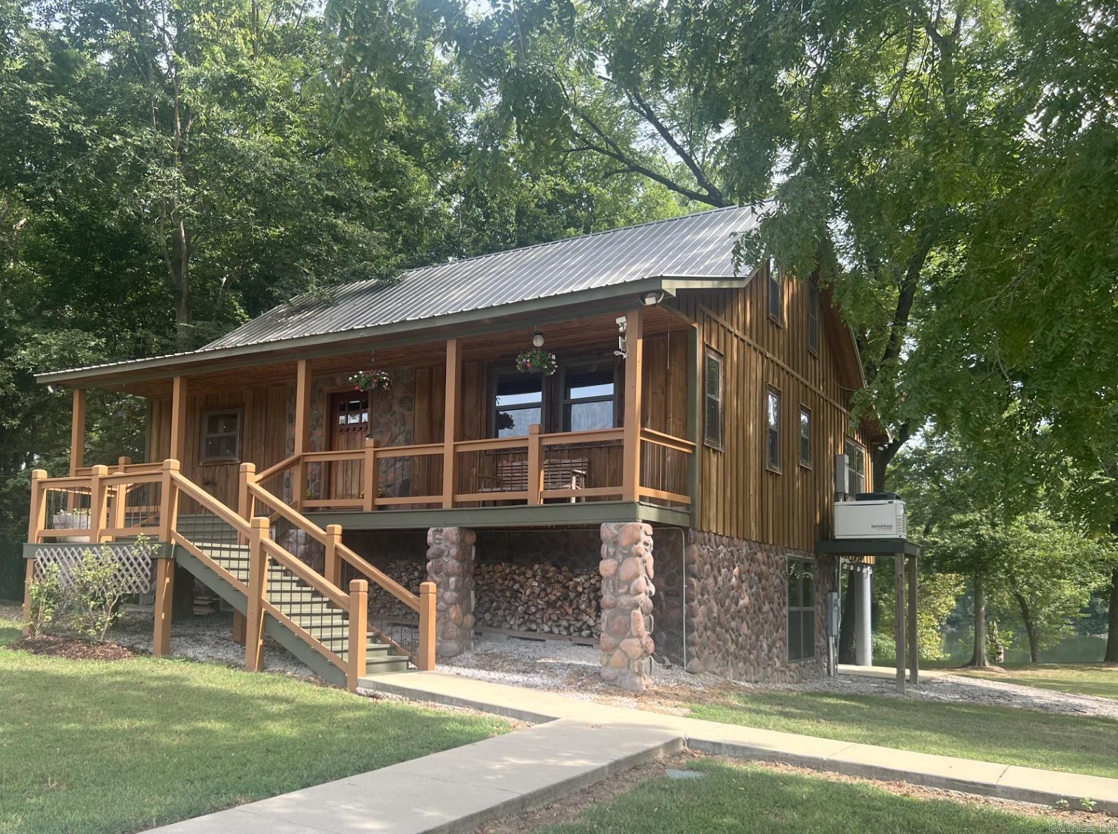 WELCOME HOME to the beautiful Ozark Mountains along the banks of the WHITE RIVER! Use this custom built 4 bedroom, 3.5 bath cypress and rock cabin as your permanent home or as a VRBO. Fully furnished with appliances from both kitchens included as well as multiple televisions. Features include gorgeous milled wood floors on main levels, full kitchens on main level and walk-out basement level, unique burnt copper accessories, and the most relaxing back covered patio where you can rock the day away! Secluded Gated Subdivision has a property owner's boat launch. Then you can tie your boat up and fish from your own backyard! Outside offers a full RV hookup, a storage building, a garden spot, fruit trees, blackberry vines, a full home generator, and 3 lots! And, yes, there's excellent fiber internet if you need to work from home! Perfect place for making FAMILY MEMORIES!