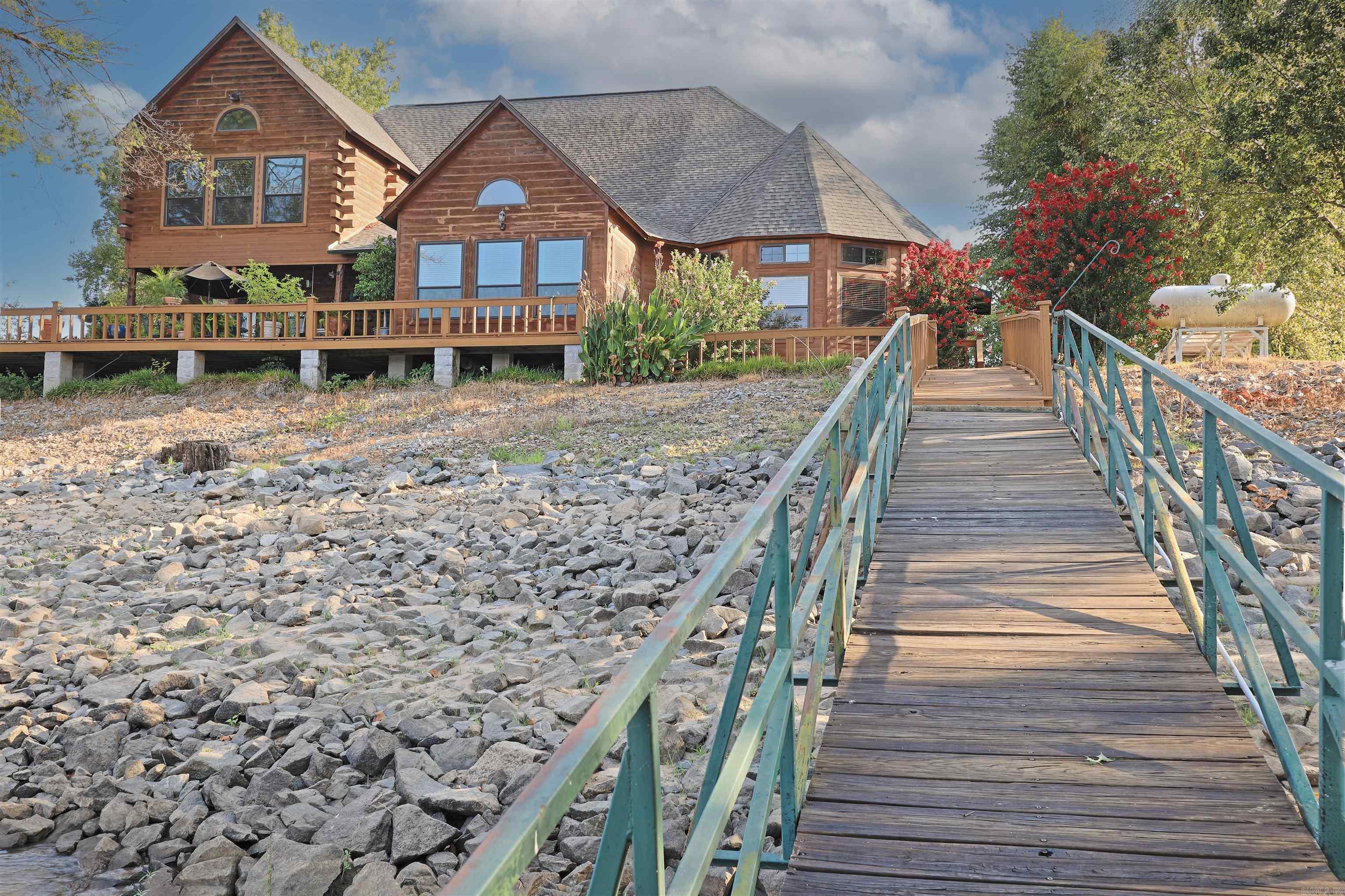 Experience true riverfront living on the Arkansas River with this stunning 4,073 sq ft home, offering 4 bedrooms, 3.5 bathrooms, and the perfect blend of comfort and outdoor adventure. Step outside to your own in-ground pool, enjoy direct water access with two covered boat slips, and take in breathtaking river views every day. Inside, the home boasts a bright and open floor plan with large windows framing views of the water. The kitchen offers ample counter space and storage, flowing into the dining and living areasāperfect for entertaining. A sunroom overlooking the river provides a peaceful retreat year-round, while the upstairs balcony delivers a front-row seat to stunning sunsets. The primary suite features its own river view and a spacious en-suite bath, and the additional bedrooms offer comfort and privacy for family or guests. The property also features a spacious 60x50 shop with a finished apartment, ideal for guests, hobbies, or extra storage. Surrounded by prime Arkansas hunting land, this home is a rare opportunity to enjoy boating, fishing, hunting, and relaxingāall from your own backyard.