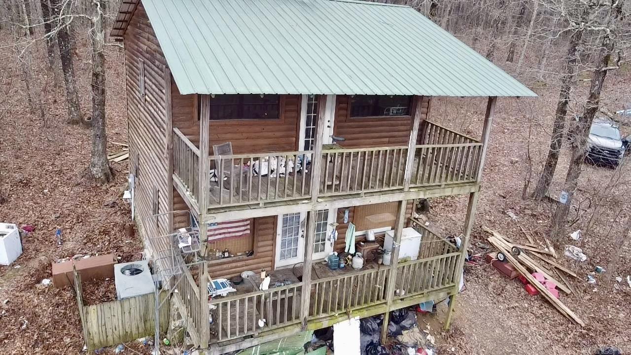 Escape to this charming 2-bedroom, 1.5-bathroom, two-story log-sided cabin, perfectly situated on 3.7 acres with breathtaking mountain views from both front covered porches. Located on a paved road, this home offers a private setting with few neighbors, making it the ideal retreat. The open-concept kitchen and living area downstairs create a welcoming space perfect for gatherings or cozy evenings. Enjoy being just minutes from the Ozark National Forest, Glory Hole Falls, & the Ozark Highlands Trail, with abundant outdoor recreation and wildlife right at your doorstep. Solidly constructed, this home offers great potential with some cosmetic upgrades necessary!!! Inside, you'll find a spacious walk-in closet with washer/dryer hookups for convenience. Don't miss this opportunity to create your perfect mountain getaway-schedule a showing today!!
