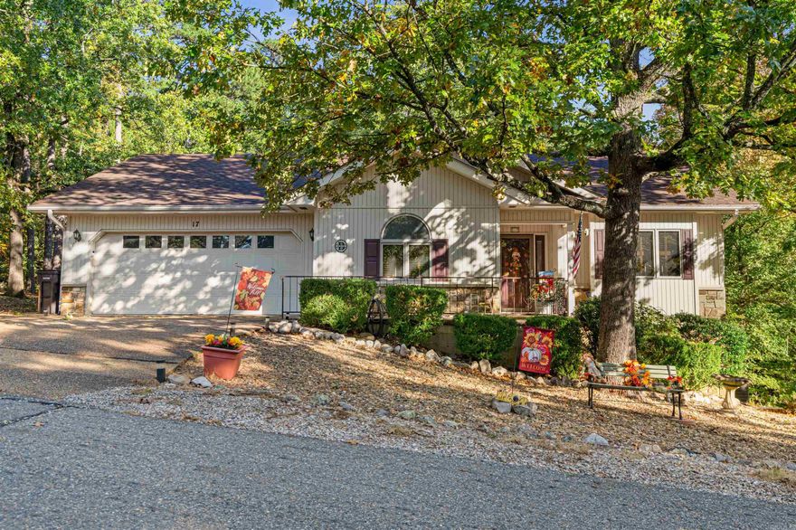 Welcome to 17 Coronado Lane, a beautiful 3-bedroom, 2-bath home offering a flat driveway and privacy thanks to a large area of common property behind the house. Super convenient! 2 minutes from fitness center, POA, churches, and trails. Quick access to Hwy 5 via Danville Gate for downtown Hot Springs. 6 minutes to Dollar General Market.  The interior features an open floor plan, showcasing hardwood floors and vaulted ceilings in both the living room and bedroom. Enjoy the seamless flow between the cozy dining area and the kitchen, which includes a convenient bar for extra seating. A stunning, large sunroom with a vaulted ceiling, abundance of windows, and serene view provides year-round enjoyment.  Notable features include a 2024 roof, peach tree windows, wood burning fireplace, and HVAC system that includes a whole house filter and Pure Aire UV Light.  A private deck extends your main-level living space. The lower level is accessed from outside and features a versatile, heated and cooled shop/game/craft room that opens onto a screened-in patio. Lower room can double as a safe room. The large backyard is perfect for outdoor activities and could easily accommodate a fence for pets.