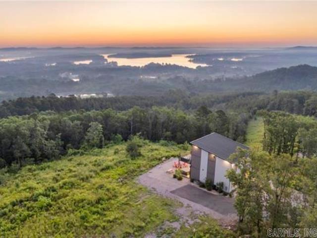This vaulted mountain villa features breathtaking vistas from the hot tub & every room in the house. Situated on Mount Riante-one of Garland County's highest peaks-with commanding views encompassing Ouachita Valley, the waters of Lake Hamilton, and Hot Springs National Park. Fully-furnished & turnkey, the open, airy floor plan features 3 bedrooms, 3.5 baths, and a sleek, modern kitchen to soak up the expansive views while cooking. You'll love having the choice of indoor dining or al fresco dining each evening with a sunset backdrop on the upper or lower deck. This picturesque haven is nestled on nearly 1 acre of land, offering privacy and ample space to add an additional dwelling, if desired. Don't miss the cozy fire pit to enjoy with friends and family, and the electric car charging station for added convenience. Currently operating as a successful, high-end vacation rental, this home is a wonderful addition to any investment portfolio. (Rental financials can be provided to qualified buyers. No STR permit required, as it is located outside the city limits.) Whether you're looking for your dream home or a great investment opportunity, this stunning home has it all.