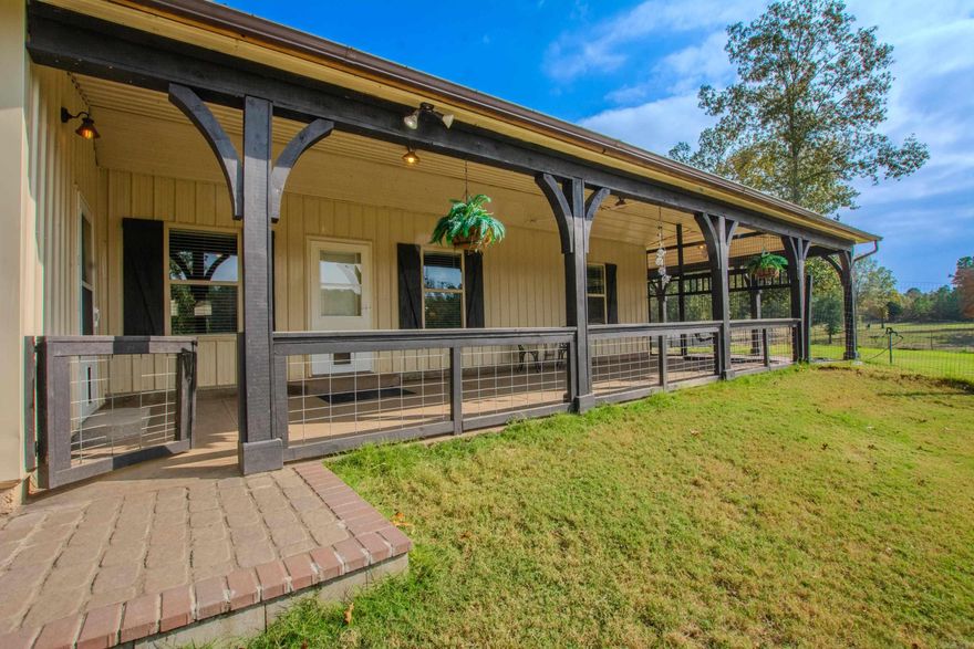 Enjoy country living at its finest on this beautiful 4.9-acre property featuring wrap-around porches, multiple fenced areas, and lush gardens with fruit trees. Several options for a 3rd bedroom or more. The grounds include a chicken coop, a relaxing gazebo, and a semi-in-ground pool—perfect for entertaining or unwinding outdoors. With plenty of space to roam and relax, this property offers the ideal blend of comfort, privacy, and rural living. Now priced 30000.00 below appraisal. The room features a vaulted pine ceiling with exposed beams, creating warmth and character that extends throughout the home. The rich wood tones are beautifully complemented by sleek, dark accent walls and recessed lighting, creating a cozy yet sophisticated atmosphere. The kitchen, seamlessly connected to the living area, showcases a large breakfast bar with seating, stainless steel appliances, and two-tone cabinetry that ties the rustic and modern aesthetics together. Luxury vinyl plank flooring runs throughout, enhancing the room’s open flow and durability. Two large bedrooms can serve as a primary on either side of the home. Potential for 3rd bedroom (sitting room ). See agent remarks