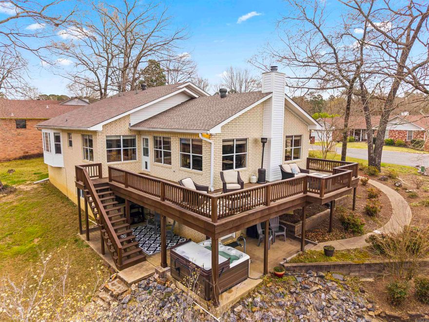 Located on a protected cove of Lake Hamilton at the end of a cul-de-sac, this updated two-story white brick home is now approved for short-term rentals! The spacious interior features open living areas and a versatile layout that includes a main-level primary suite alongside two bedrooms and a full bath, plus a finished walk-out lower level offering a fourth bedroom with its own full bath. The yard leads down to 102 feet of private shoreline with a water's-edge patio. Major updates include a new roof (2023), updated plumbing and toilets (2024), and a new water heater and dishwasher (2025). Finally, a low $150 annual HOA fee provides access to a private neighborhood boat launch, trailer storage, and community maintenance.
