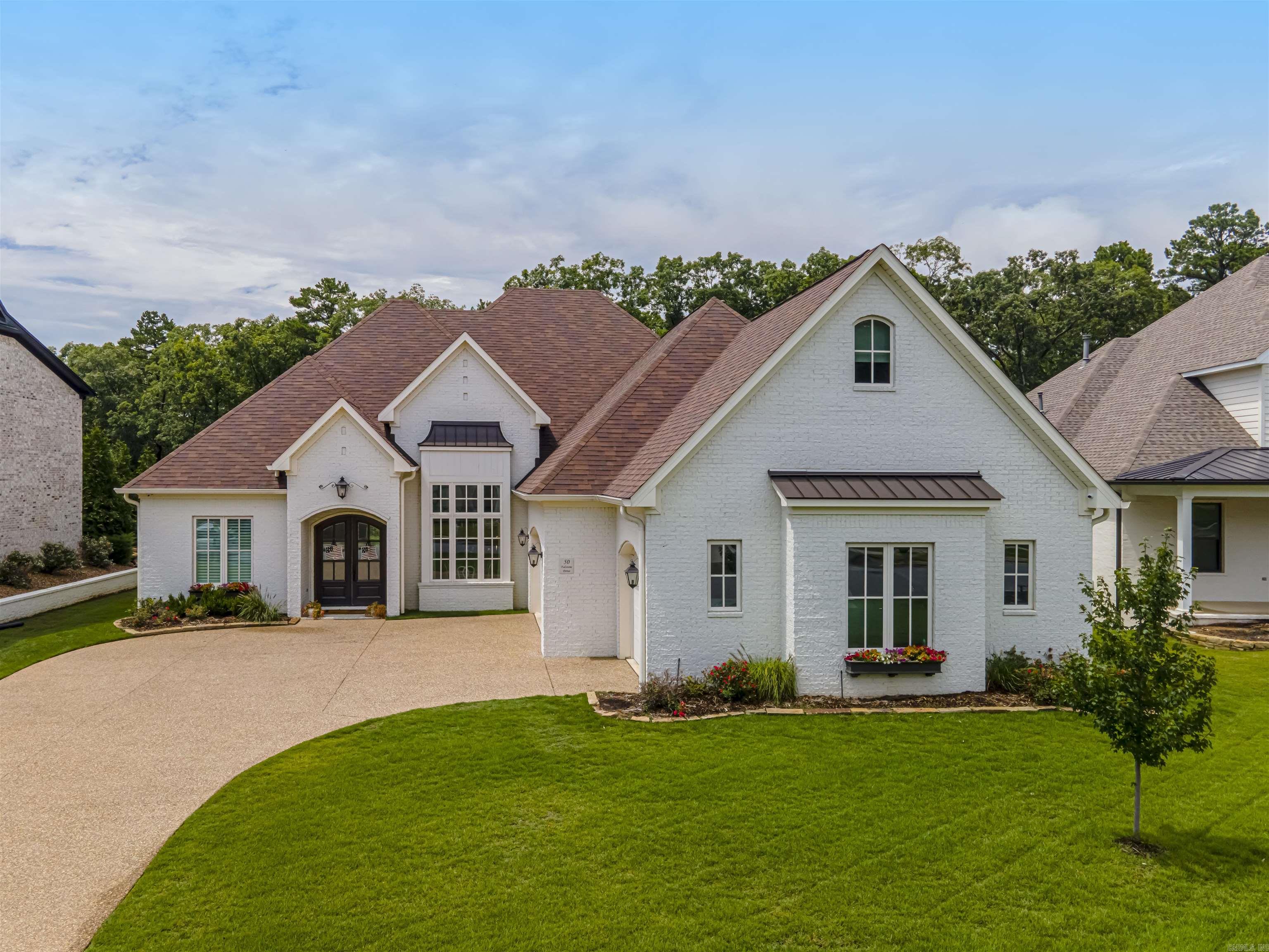 Welcome to the coveted Falstone Courts. This beautiful custom home, in like-new condition, has too many premium features to list! This home boasts 4 Bedrooms, 3 full bathrooms, 1 half-bathroom, a downstairs office, 2 bonus rooms upstairs, a laundry room with a utility sink, a 3-car garage (with over 125 sq ft of closet space), and an oversized covered back porch with a wood-burning fireplace. The open floor plan seamlessly flows from the front door to the grand dining room (with custom 15-foot window treatments), cozy living room (with a wood-burning fireplace), chef's kitchen (with a professional-grade Fisher & Paykel range), to your breakfast nook overlooking the woods of Chenal Valley. Retreat to the large primary suite and find a soaker tub, tiled shower (with a rain shower head), and a MASSIVE closet that connects to the laundry room. Upstairs, you will find two bedrooms connected by a jack & jill bathroom, each with its own vanity and toilet. You will also find 2 bonus rooms with unlimited potential. Other notable features of this amazing home include a whole-home generator, video surveillance, and a dry bar with a beverage cooler. Come see why you belong at 50 Falstone Drive